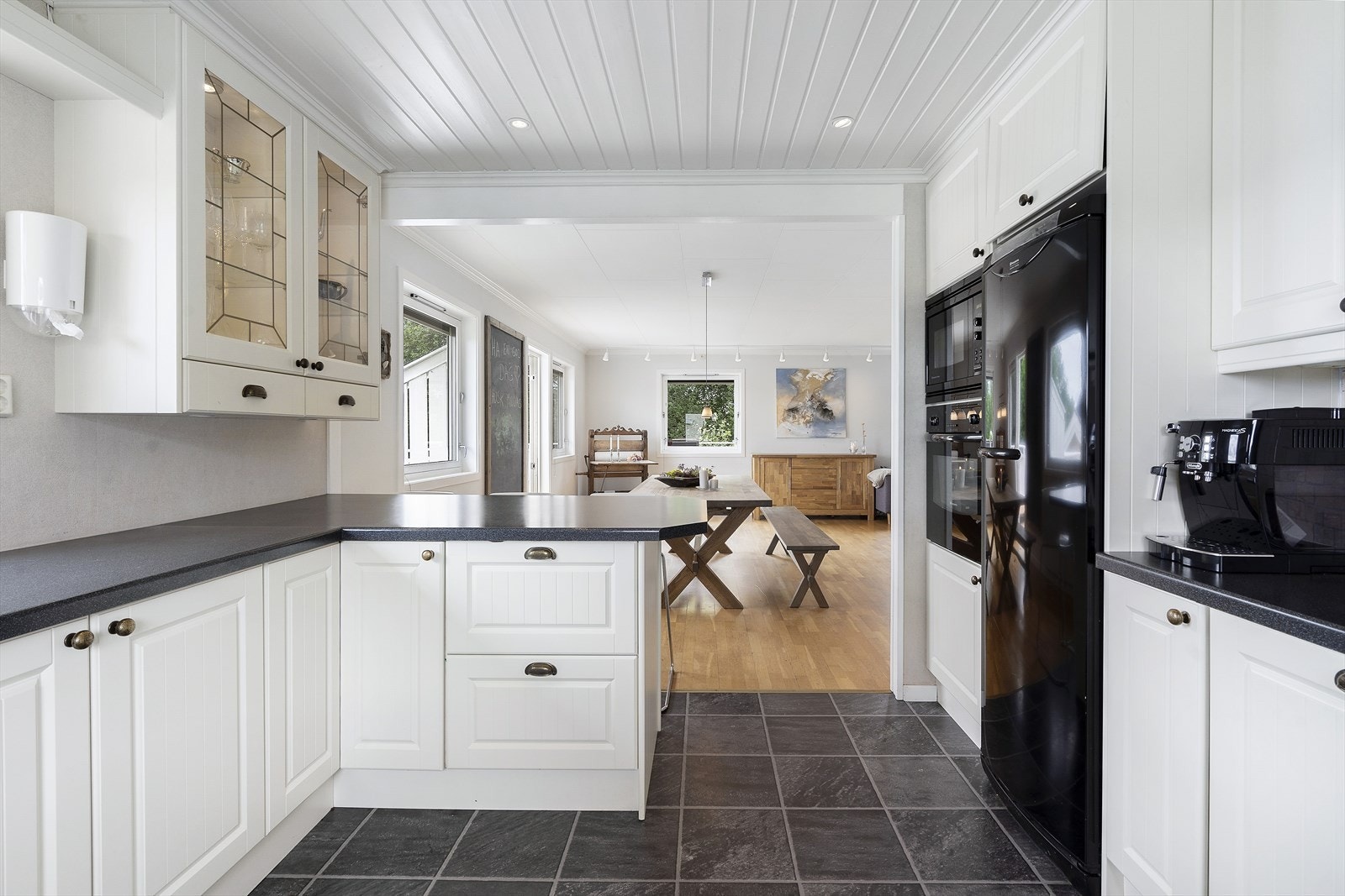 Kjøkkenet har vegger med tapet, gulv med laminat og himling med malt panel. Galleribilde