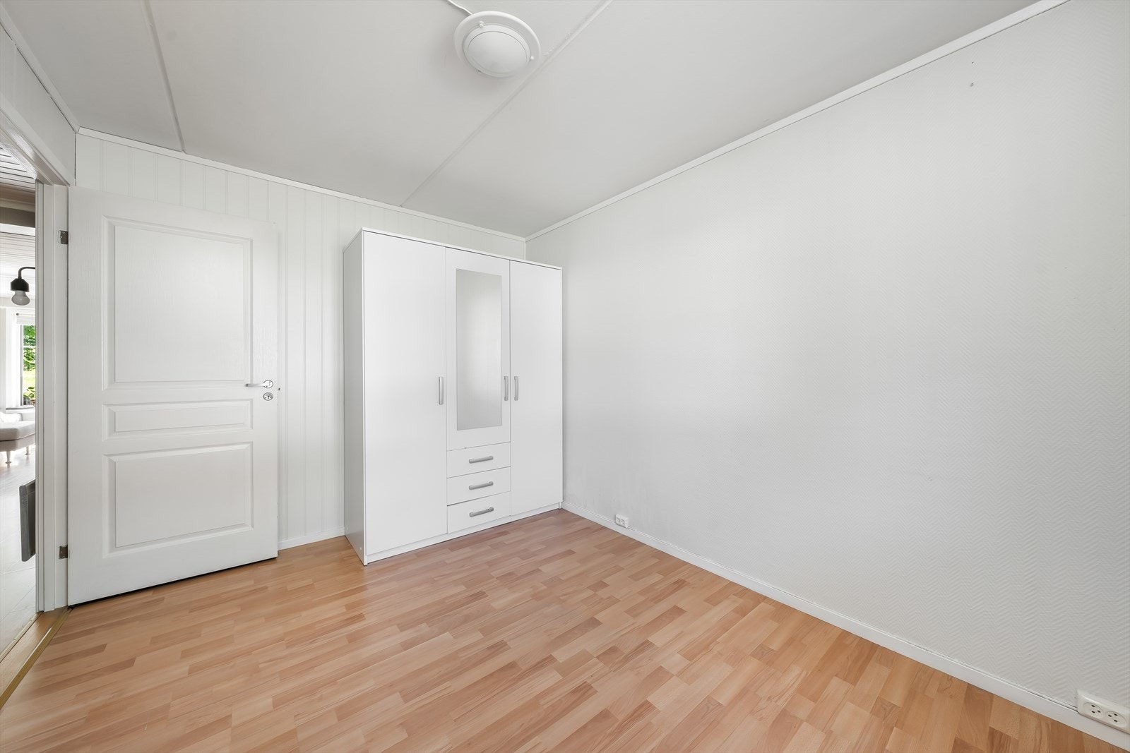 Det andre soverommet har romslig garderobeskap med god plass til klesoppbevaring, laminat på gulv og hvitmalt glassfiberstrie, samt panelplater på vegger. Galleribilde