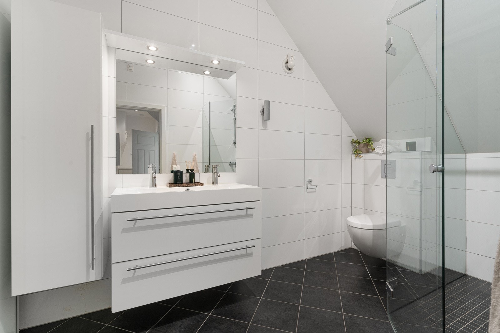 Her finner du en dusjnisje, vask med underskap og skyvedørsskap. Galleribilde