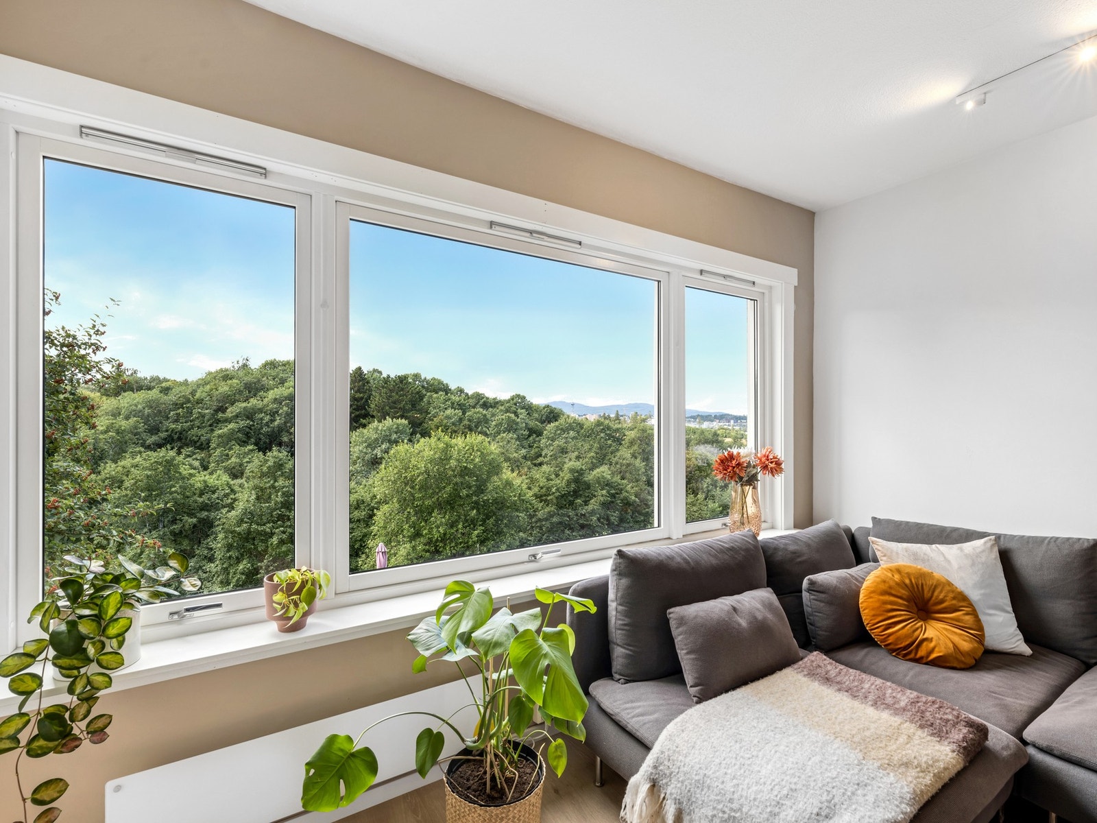 De store vindusflatene gir et godt lysinnslipp, og med utsikt mot friområde bidrar dette til leilighetens lette og luftige atmosfære. Galleribilde