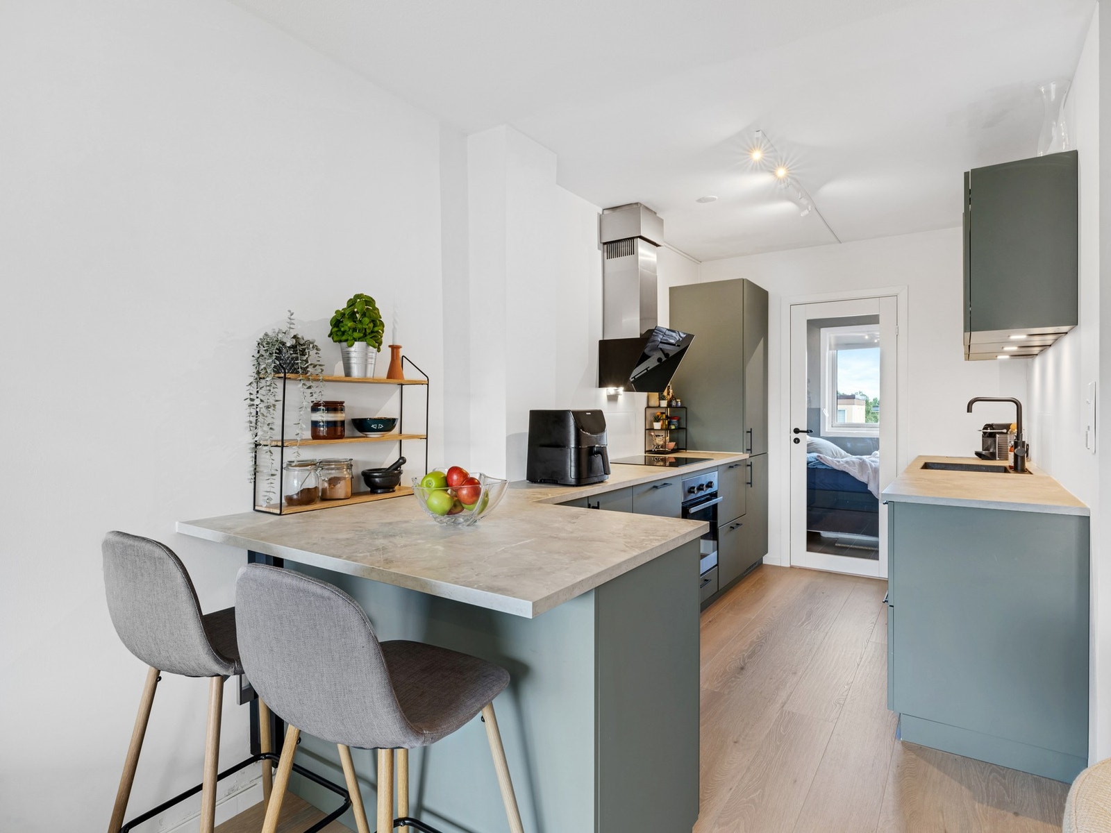 Stilrent kjøkken fra 2022 med integrerte hvitevarer, praktisk barløsning og mye benkeplass. Legg merke til glassdøren som adskiller, men samtidig gir et godt gjennomlys på kjøkken. Galleribilde