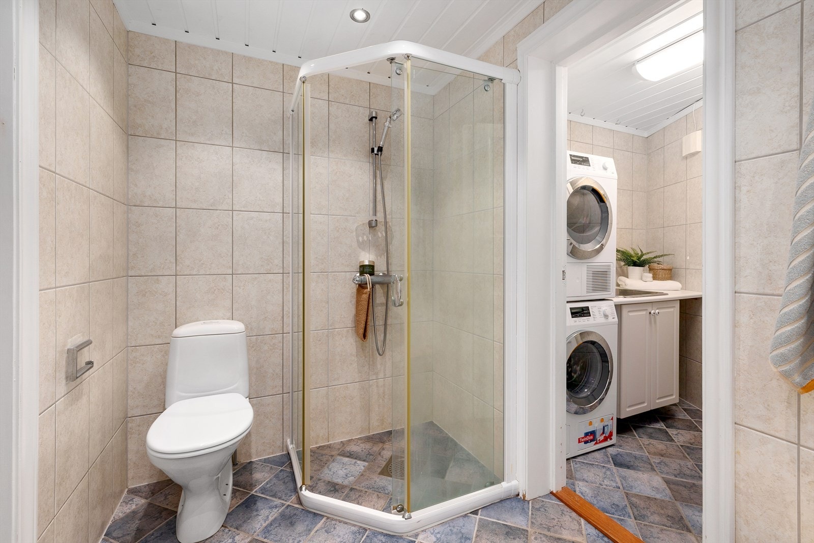 Badet i første etasje har toalett og et dusjhjørne med fast ramme. Innenfor badet ligger vaskerommet. Galleribilde