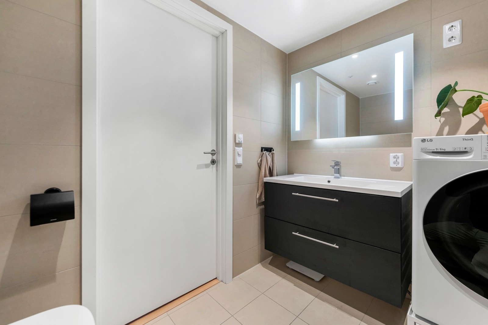 Slett svart innredning med servant, regnfallsdusj med innfellbare dører i glass, vegghengt wc og downlights i himlingen som sørger for godt med lys. Opplegg for vaskemaskin/tørketrommel Galleribilde