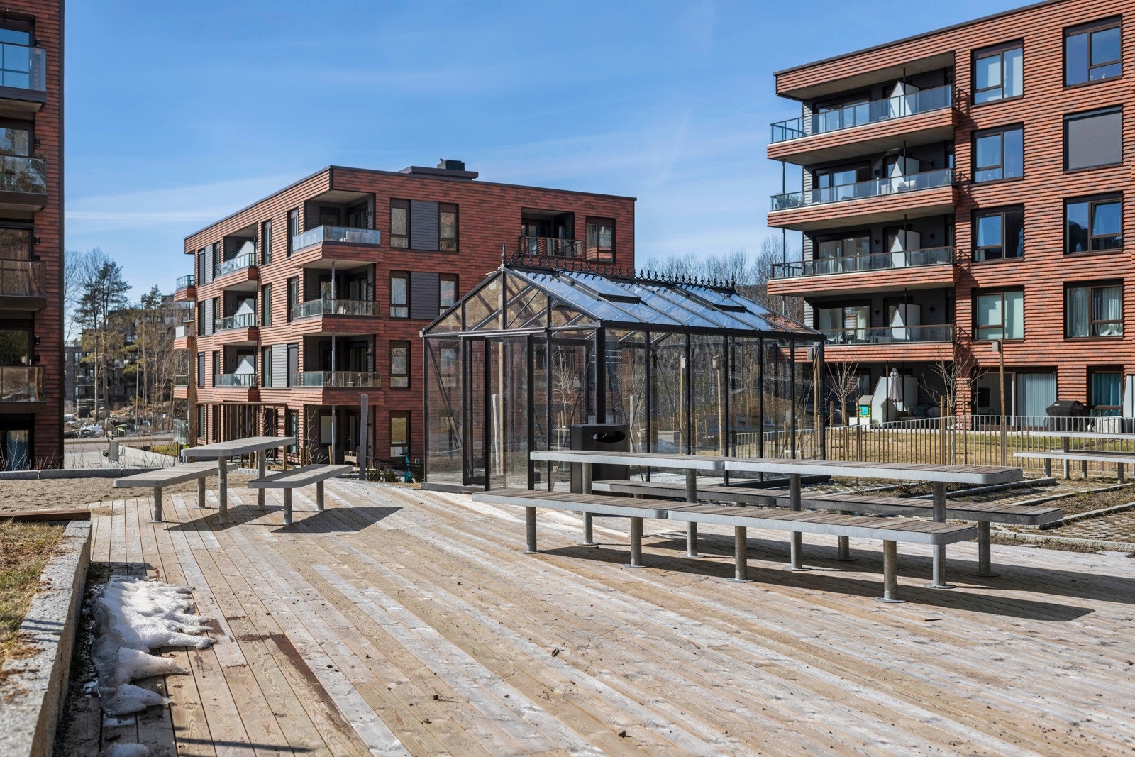 Meget pent fellesområde med sittegrupper, utestue, beplantning og skøytebane om vinteren Galleribilde