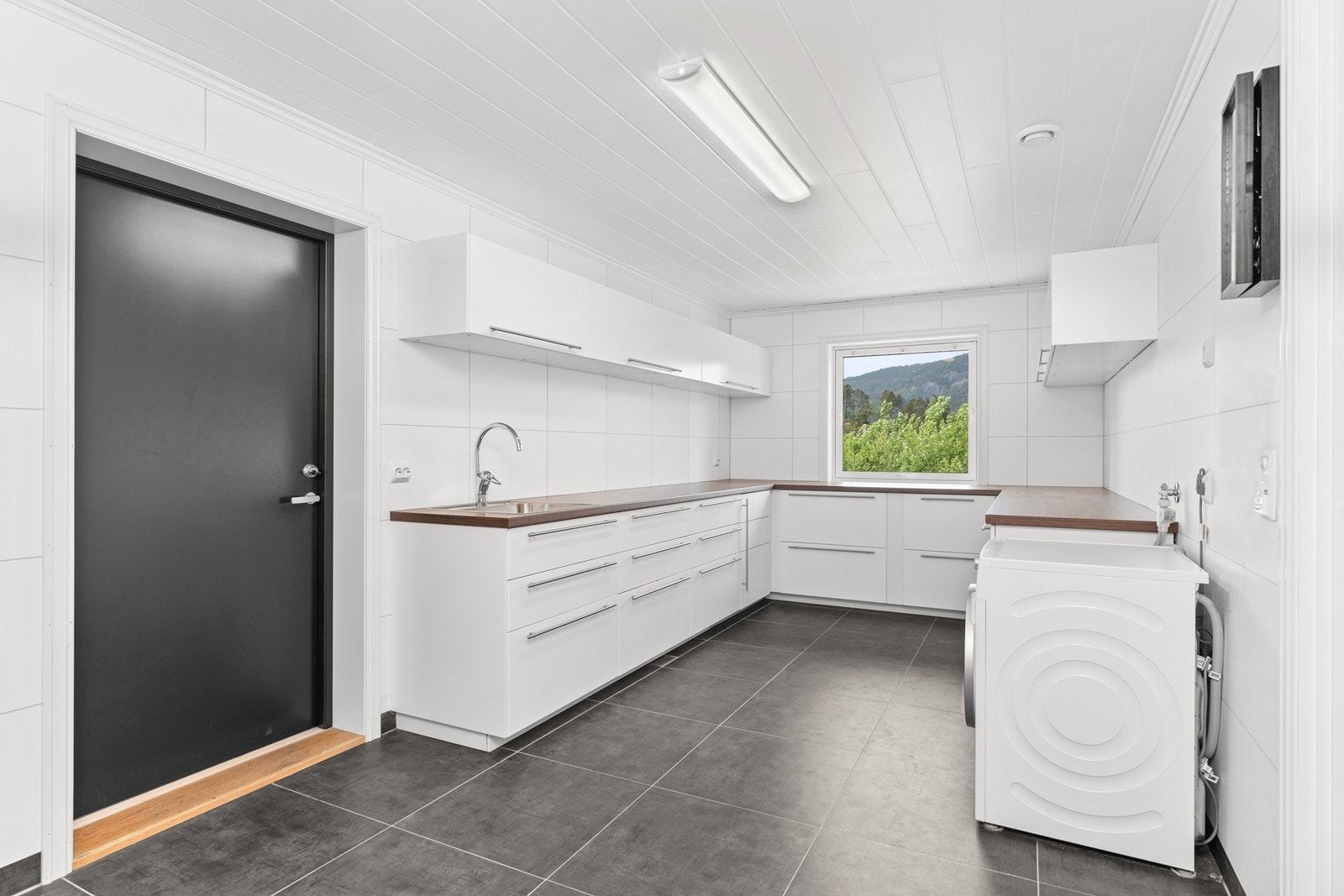 Praktisk vaskerom med god skap- og benkplass. Adkomst gjennom bod til garasje Galleribilde