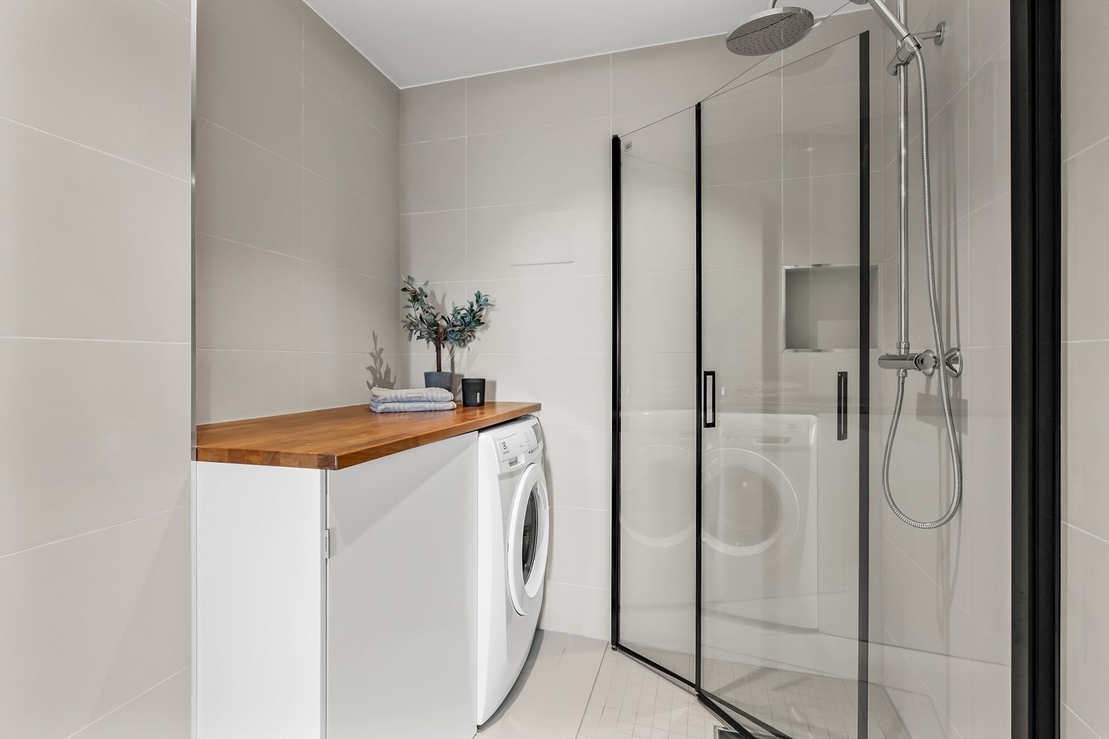 Badet har opplegg for vaskemaskin og har dusjnisje med regn- og håndusj Galleribilde