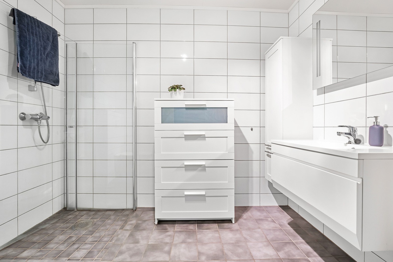 Baderom ligger i 1.etasje og har en god romløsning. Vegghengt toalett til venstre utenfor bildet. God plass til oppbevaring i både skuffer og skap. I tillegg har boligen separat vaskerom samt gjestetoalett. Galleribilde