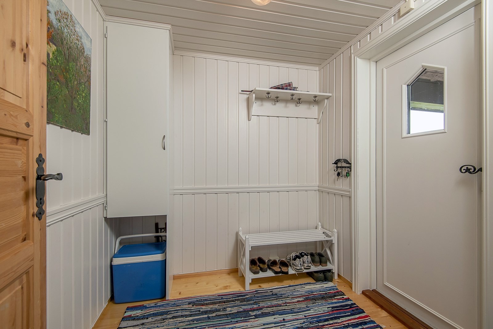 Gang/vindfang via terrasse/overbygget inngangsparti. Lyst og innbydende. Galleribilde