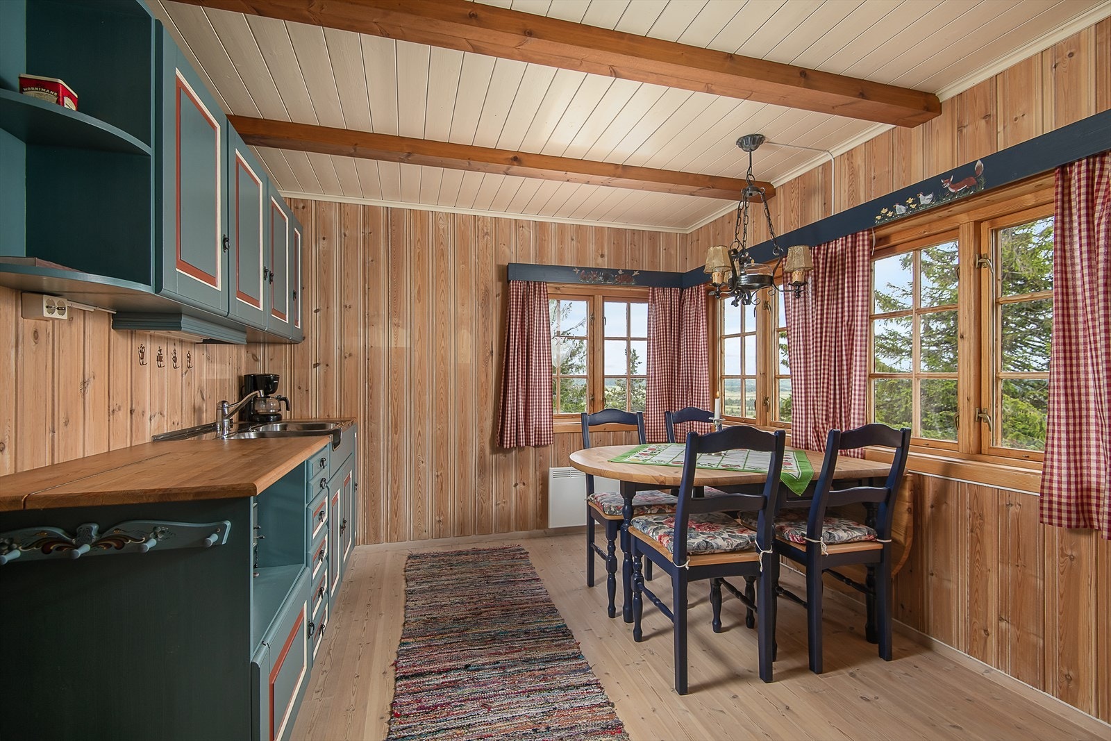 Innredning i heltre, malt utførelse. Over-og underskap for oppbevaring. Hyggelig med kjøkkenbordet ved vinduet. Fint lys og mulighet til å nyte utsikten. Galleribilde