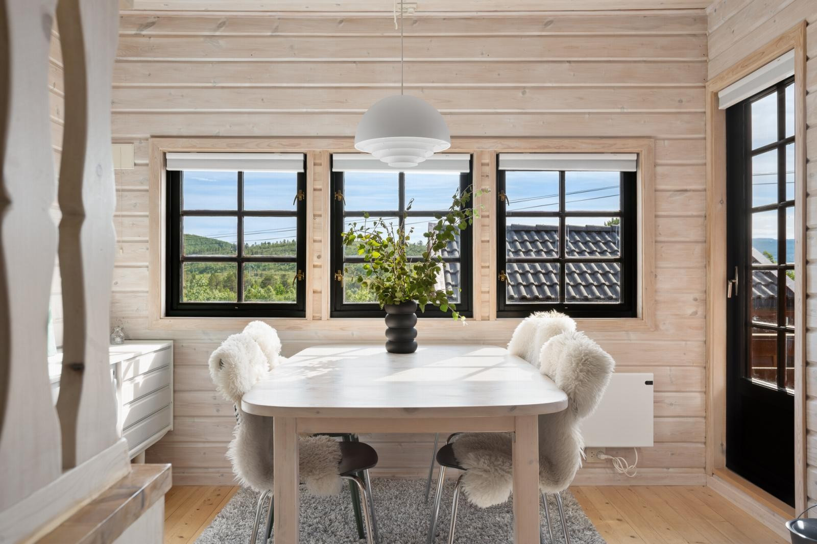 Store vindusflater som trekker naturen inn i spisestuen.