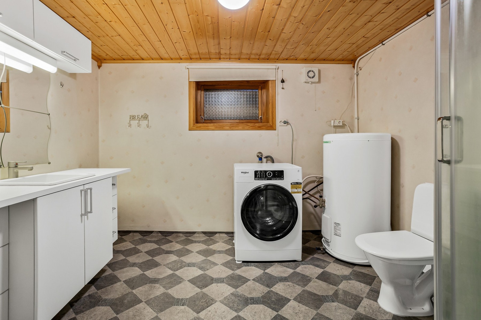 Badet har belegg på gulv, våtromsplater på vegger og panelt himling Galleribilde