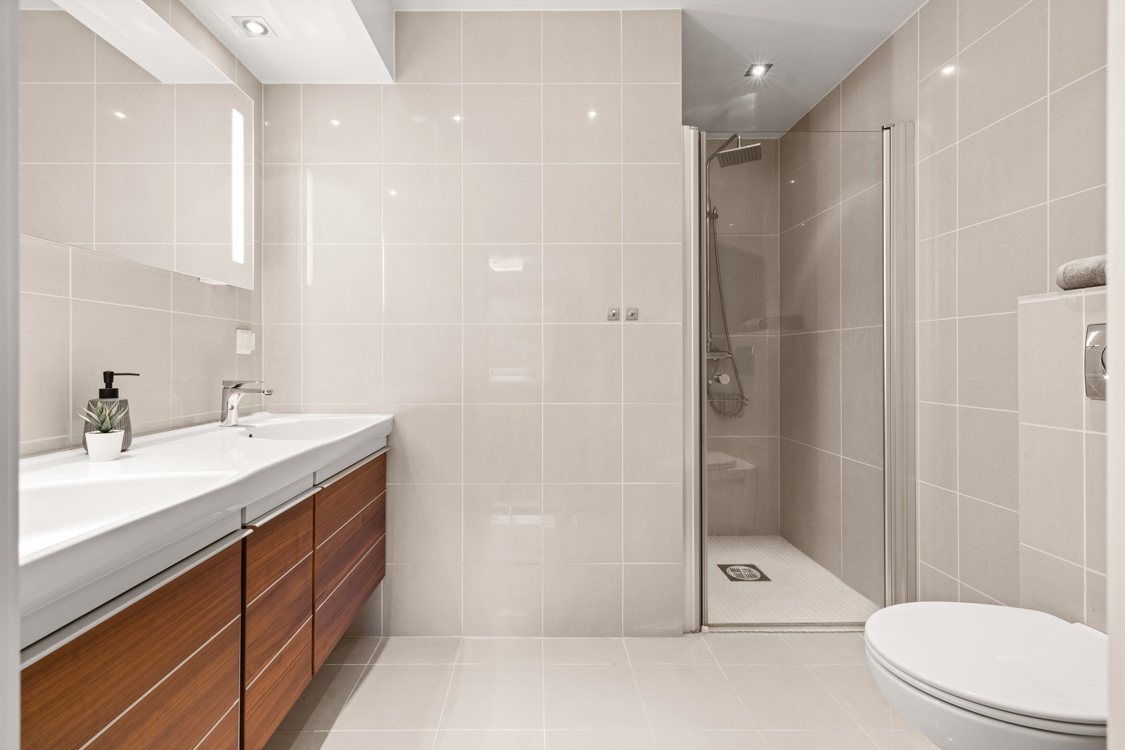 Bad - med adkomst fra hovedsoverom: Nedsenkede servanter i porselen med ett-greps armaturer. Galleribilde