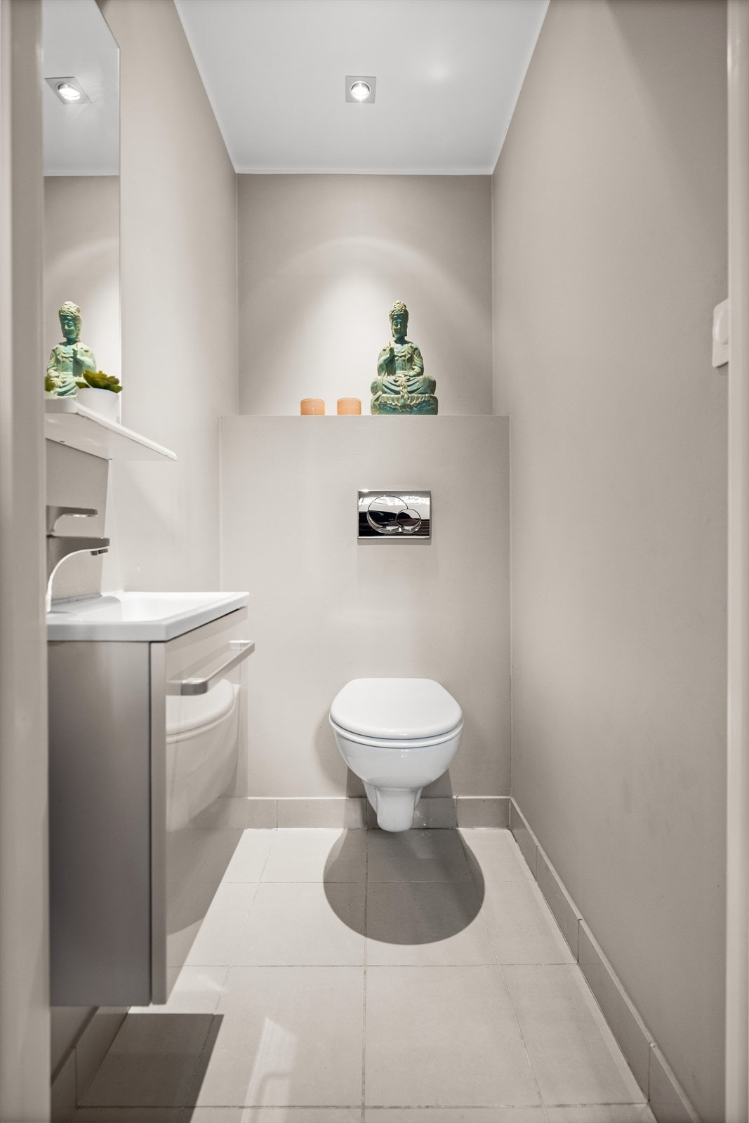 WC: Toalettrom fra byggeår. . Servantskap med slett dør i høyglans hvit utførelse og nedsenket servant i porselen. Vegghengt toalett. Galleribilde