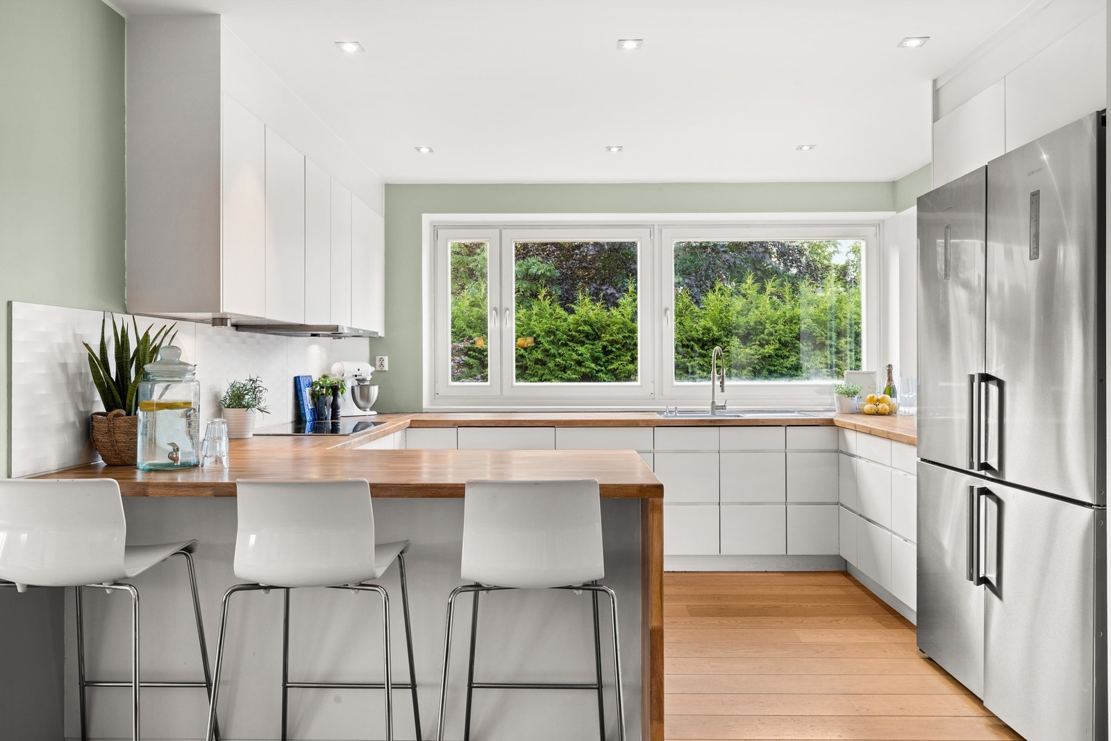 Pent kjøkken fra byggeår. Kjøkkeninnredning med slette fronter i matt hvit utførelse. Galleribilde