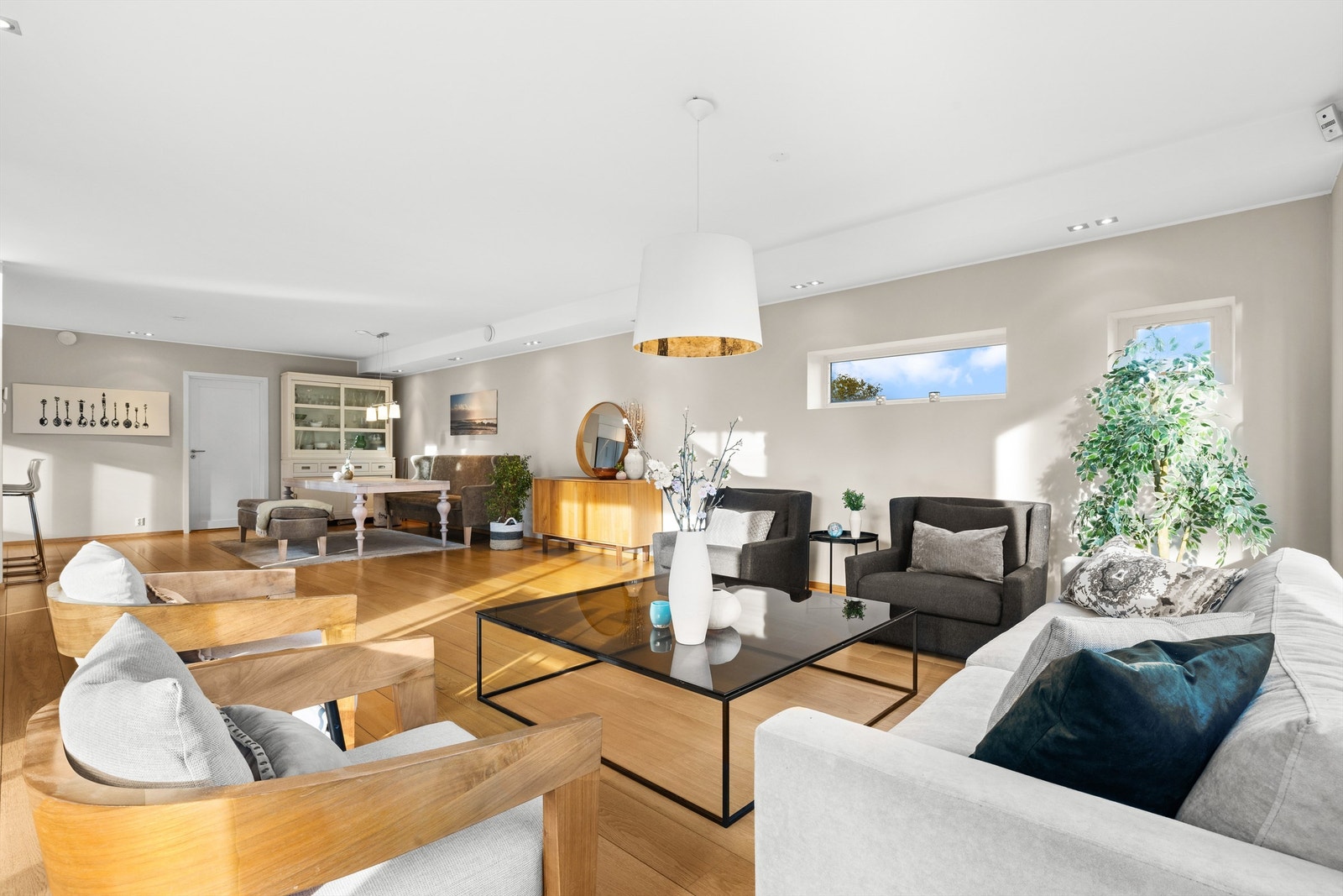 Lys og moderne stue med store vinduer som slipper inn rikelig med naturlig lys. Galleribilde