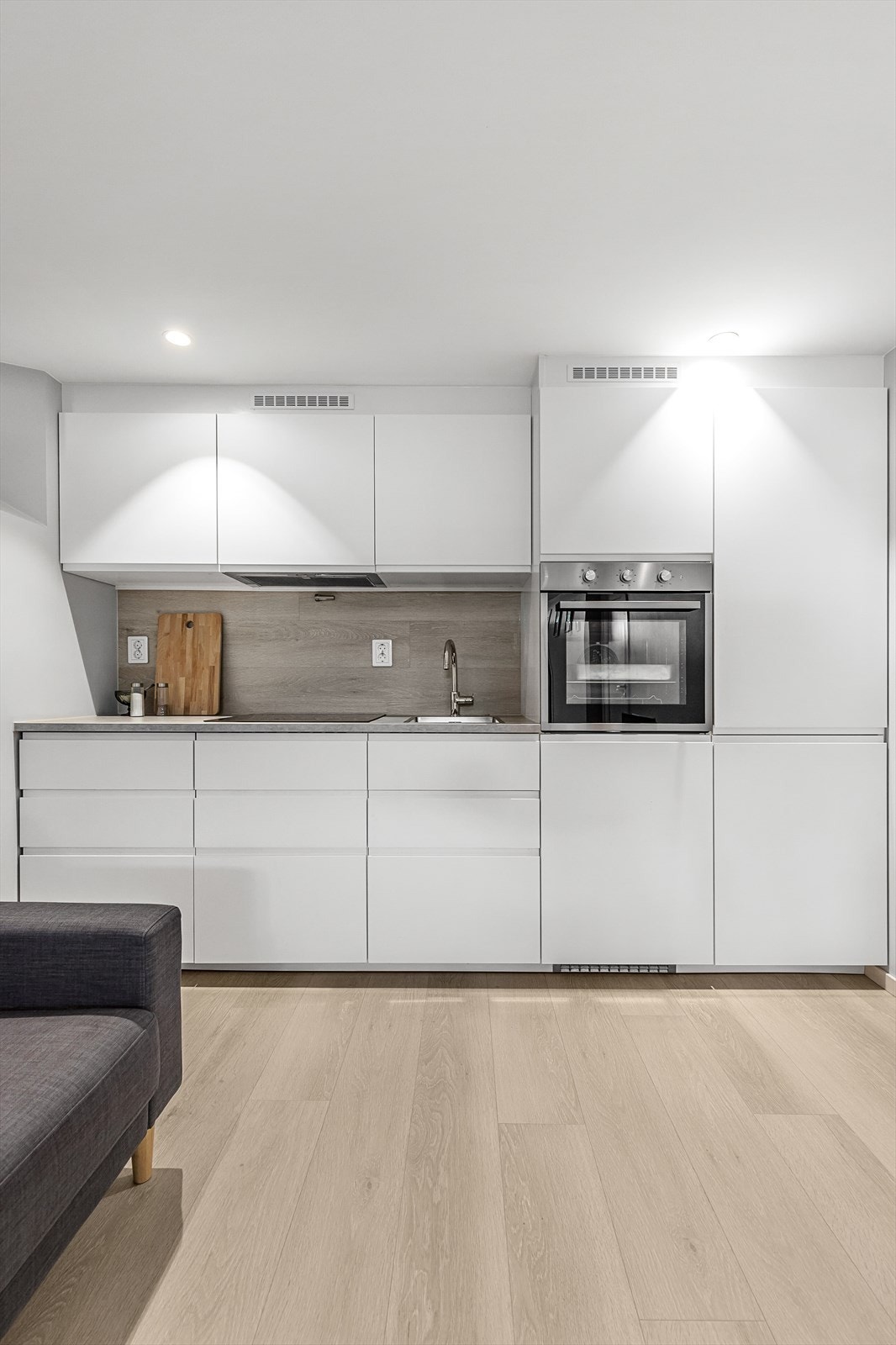 Pent kjøkken med innredning fra IKEA. Integrerte hvitevarer som kjøl- og fryseskap, stekeovn, induksjon platetopp og oppvaskmaskin. Galleribilde