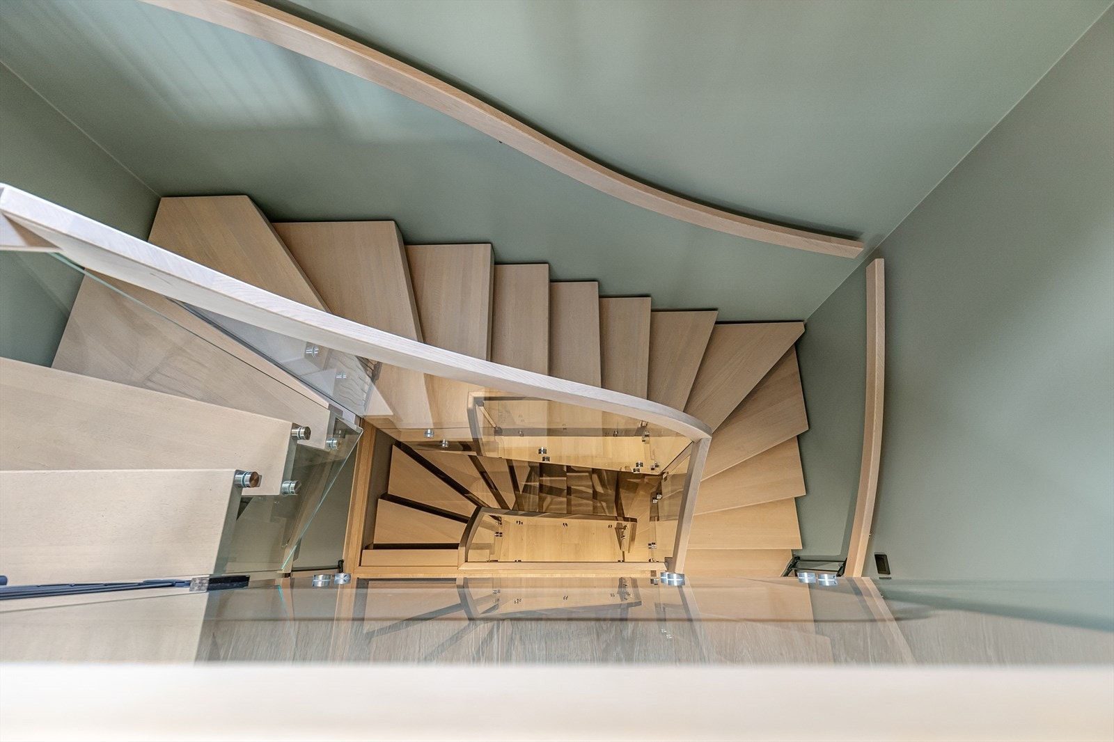 Trappen i trekonstruksjon med rekkverk i glass binder etasjene elegant sammen. Galleribilde