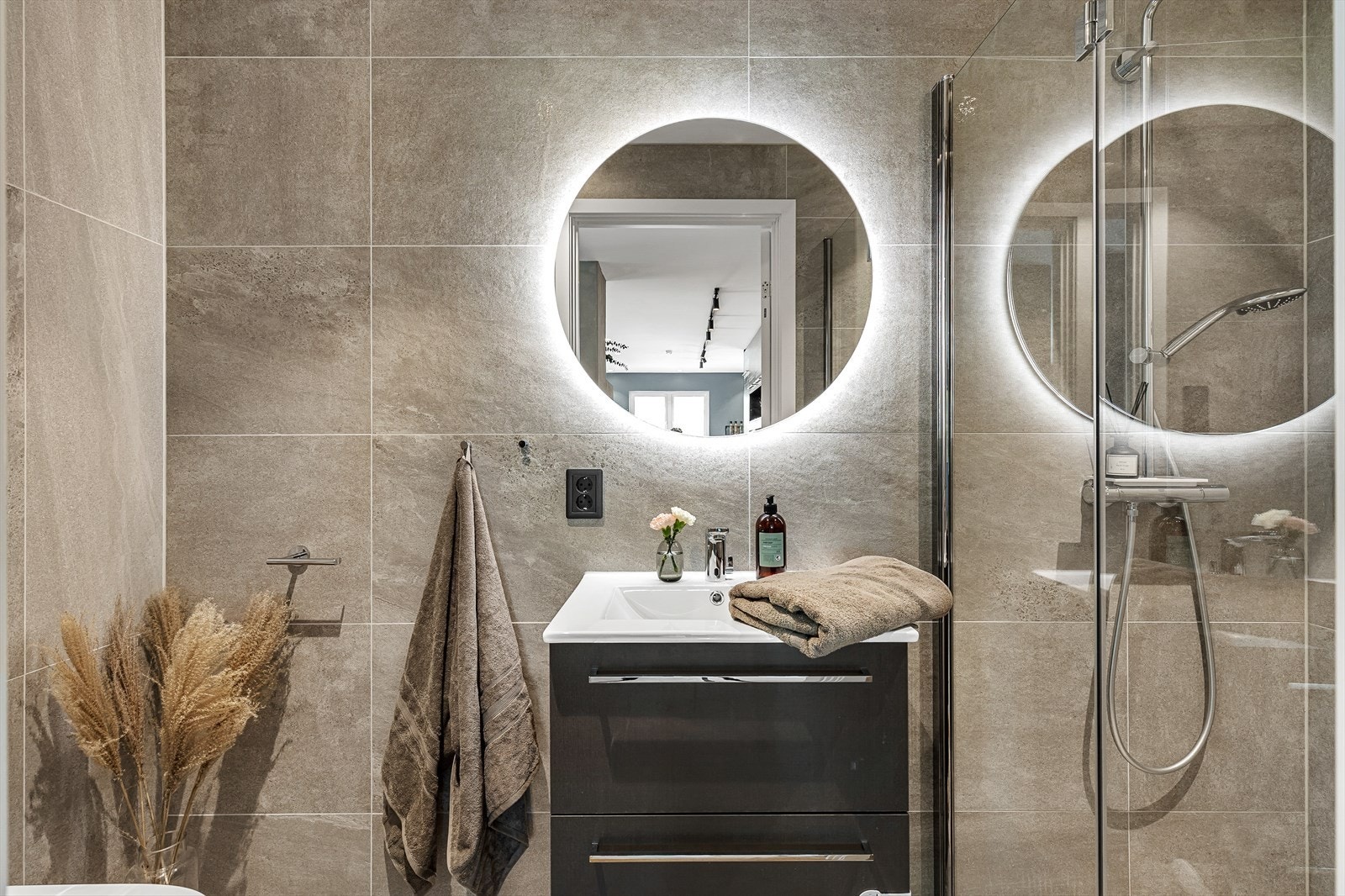 Meget gjennomført med lekre fliser, oppbevaring i skuffer og speil med integrert belysning. Galleribilde