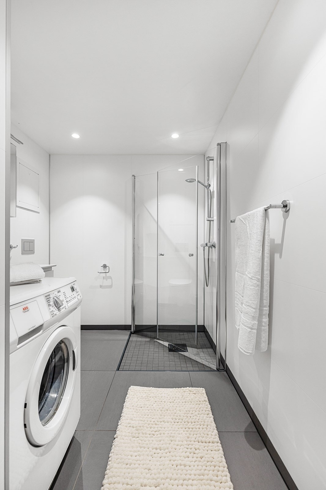 Romslig og moderne bad med plass til vaskemaskin. Galleribilde