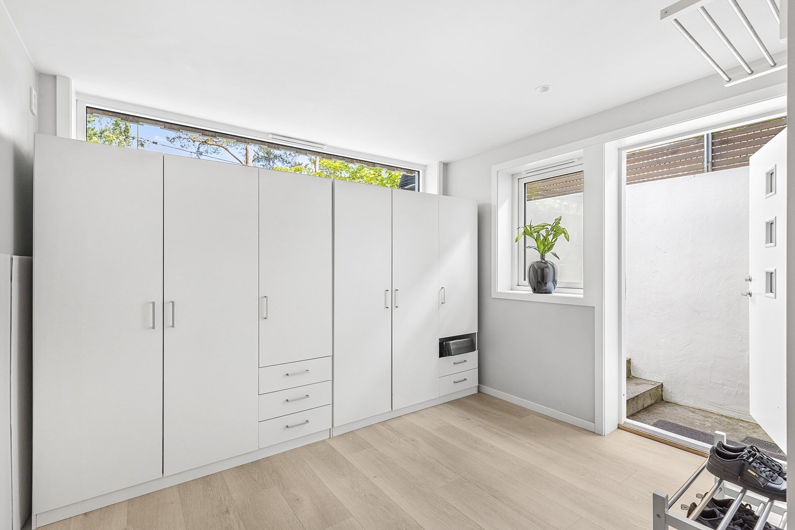 Hybelen henger sammen med hoveddelen med dør i bod. Det er også inngang utenfra, og inngangspartiet er godt skjermet fra hagen med gjerde. Galleribilde