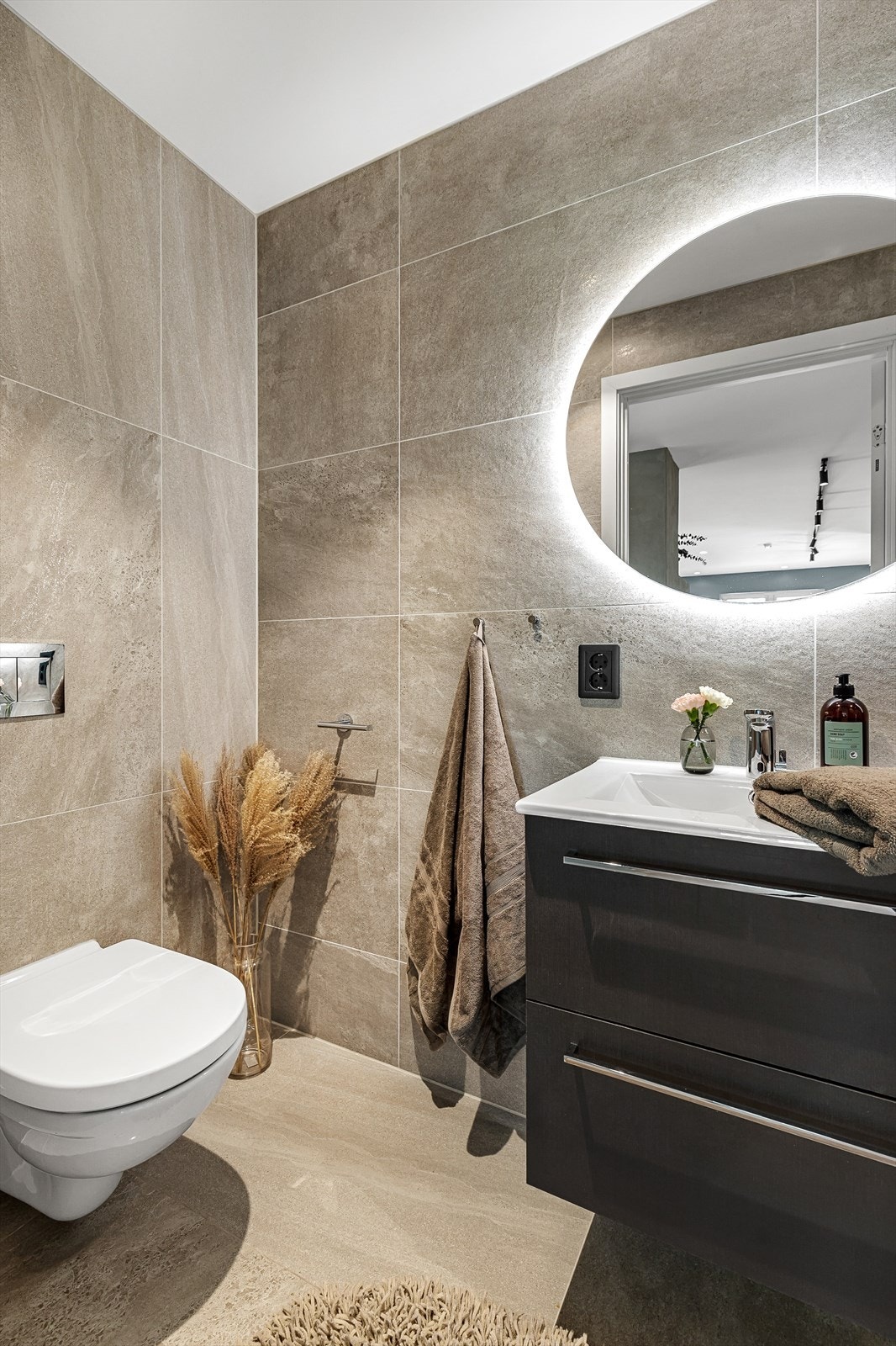 Meget gjennomført med lekre fliser, oppbevaring i skuffer og speil med integrert belysning. Galleribilde