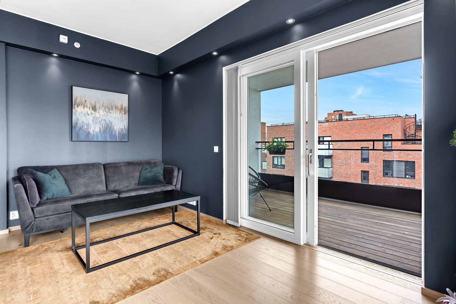 Bred skyvedør til balkongen med fastmonterte plisségardiner. Stuen har downlights fra Philips Hue. Galleribilde