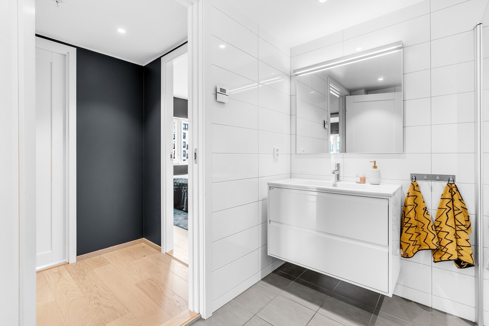 Speil med lys og baderomsinnredning med store skuffer. Galleribilde