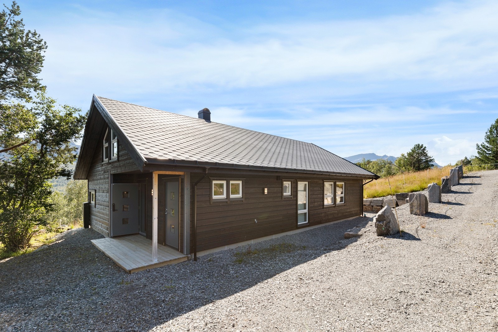 Isola skifergrå shingel på tak og liggende bordkledning fargen seterbrun. Galleribilde