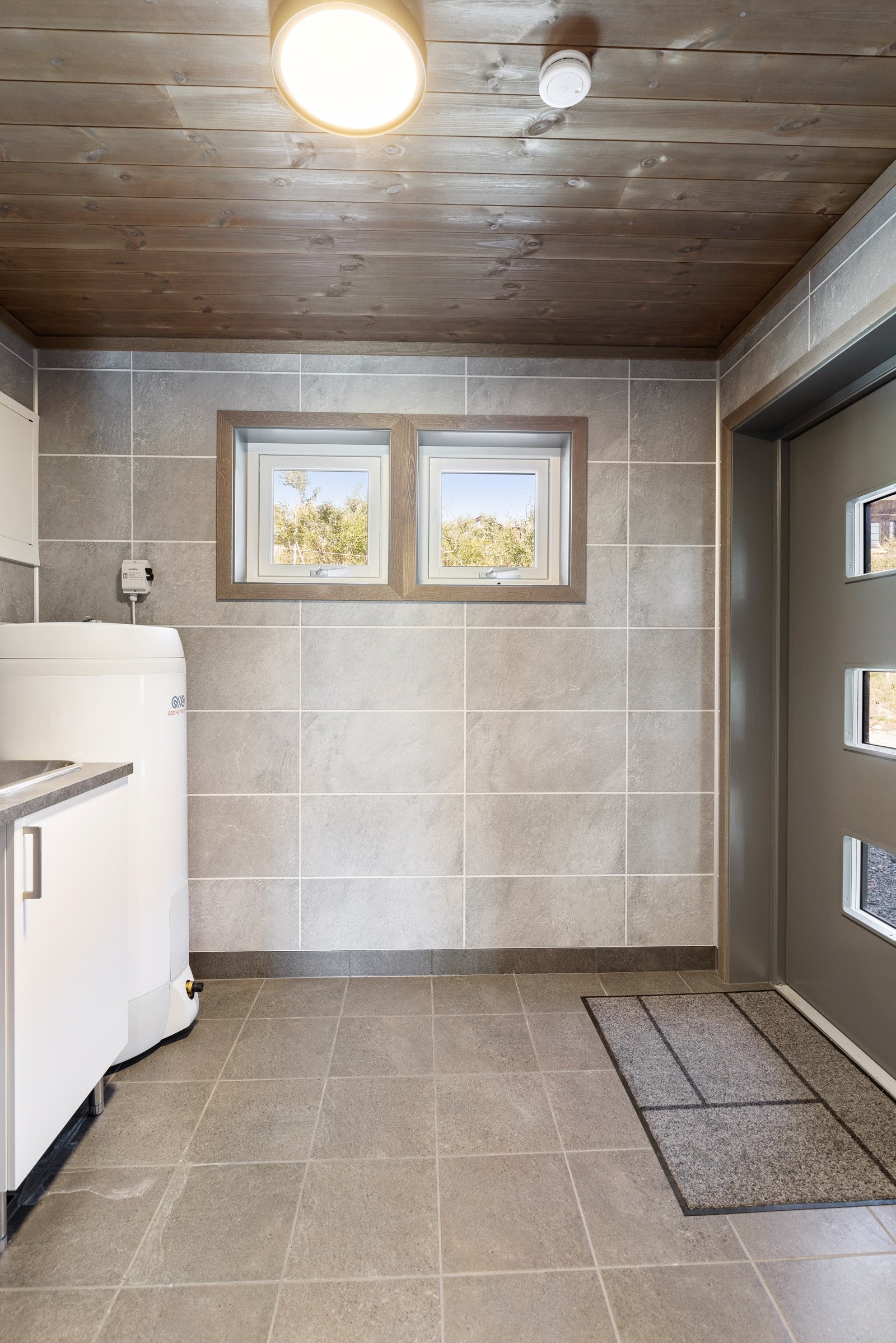 Like ved inngangen til hytten ligger separat vaskerom/teknisk rom. Rommet har en egen, praktisk inngang. Vaskerommet er helfliset og inneholder varmekabler i gulv, varmtvannsbereder, opplegg for vaskemaskin og innredning med utslagsvask. Galleribilde