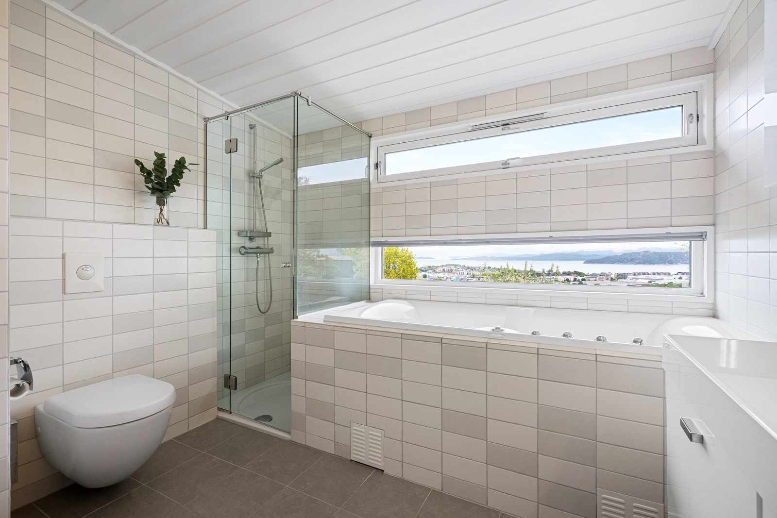 Innredet med boblebadekar, dusjhjørne, vegghengt toalett og dobbel servantseksjon. Galleribilde