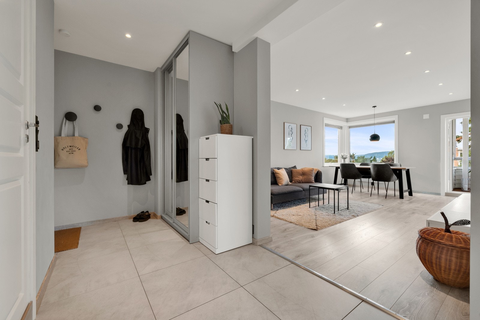 Entréen har store, sandfargede fliser på gulv, slette vegger og downlights i himling, samt en romslig skyvedørsgarderobe Galleribilde