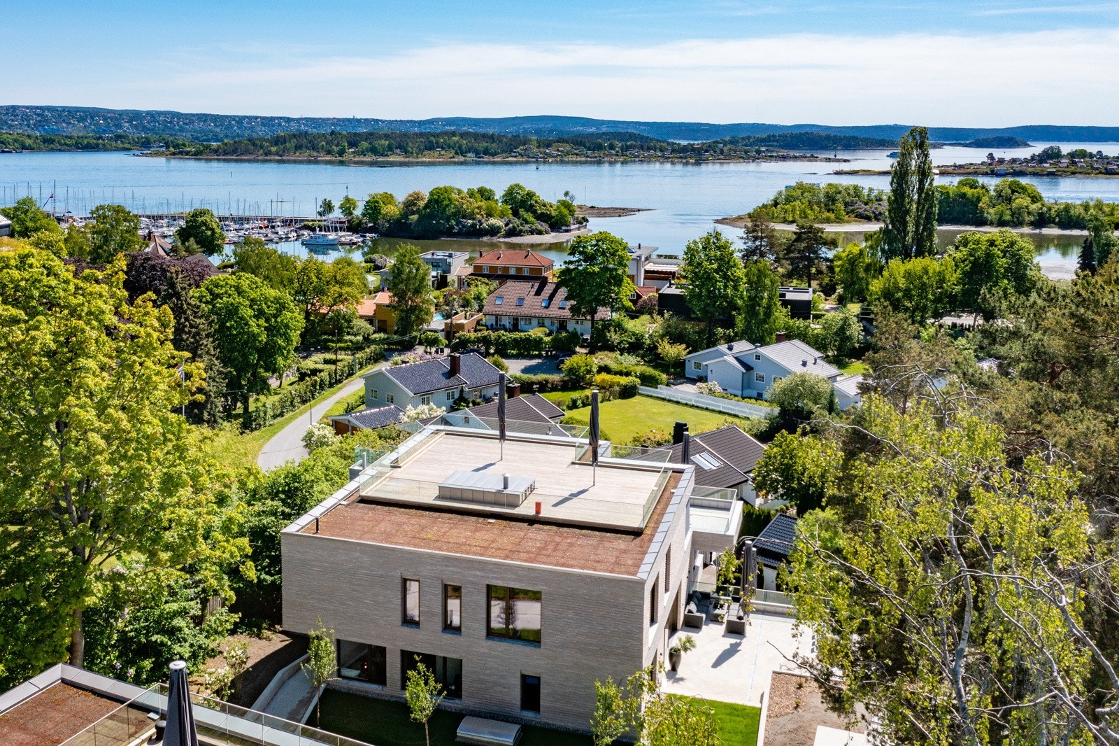 Fantastisk terrasse på 75 kvm med gode solforhold og nydelig fjordutsikt. Byggets funksjonelle, rendyrkede utforming og fasade kledd i lys tegl, står seg til det lyse betongdekket på terrassen og trappene kledd i lyse fliser. Galleribilde