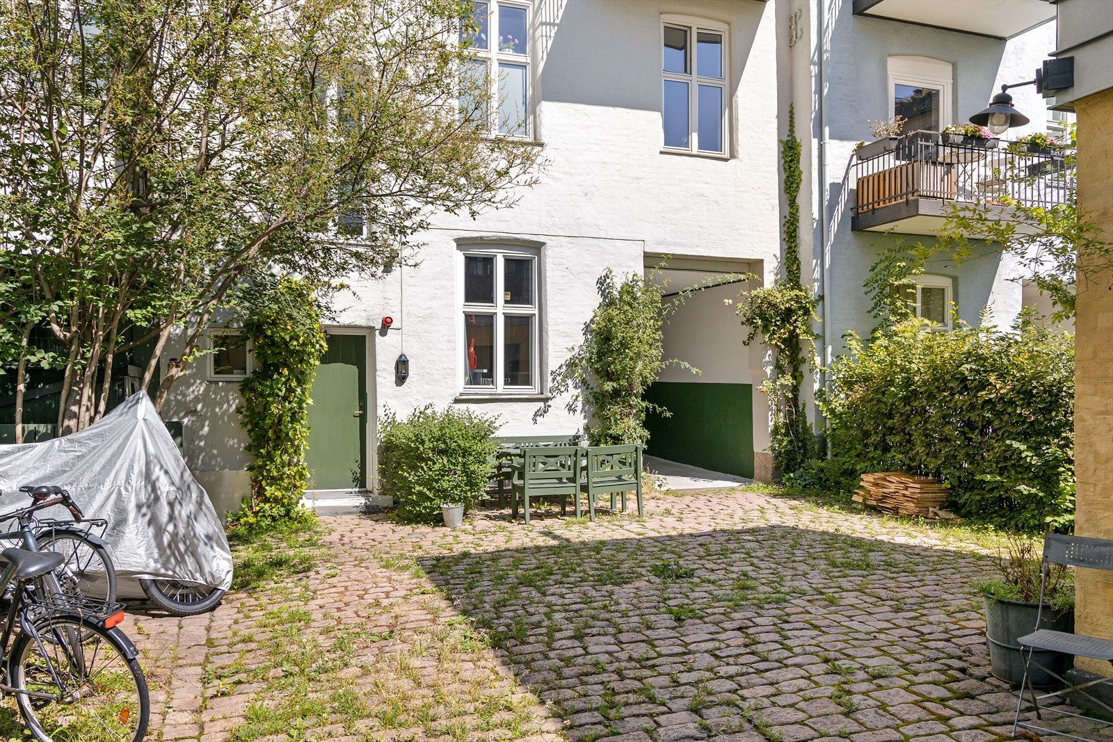 Trivelig og skjermet bakgård med brostein, diverse beplantninger og sykkelparkering Galleribilde