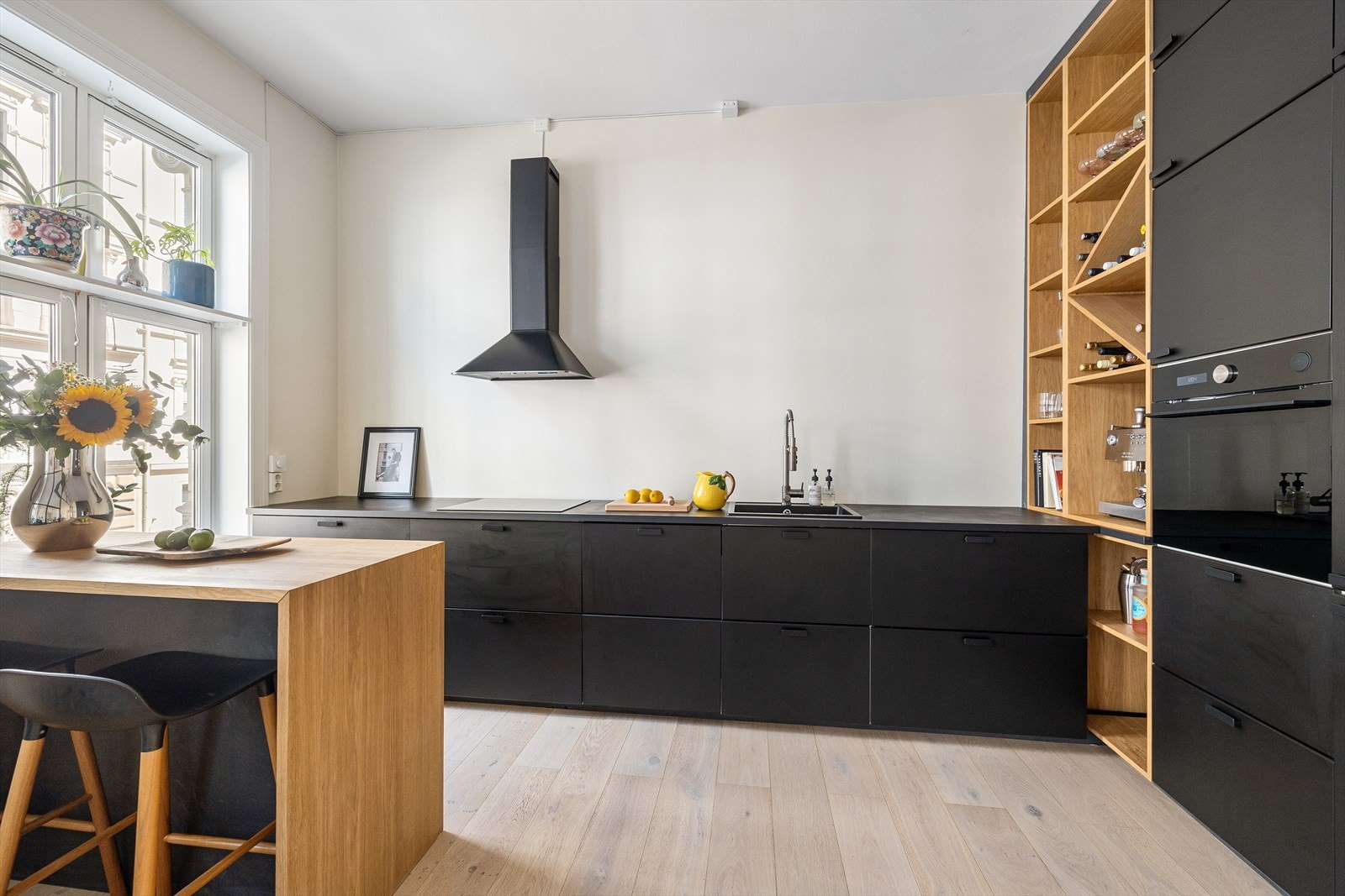 Stilrent og moderne kjøkken med slette fronter og laminat benkeplate i sort utførelse Galleribilde