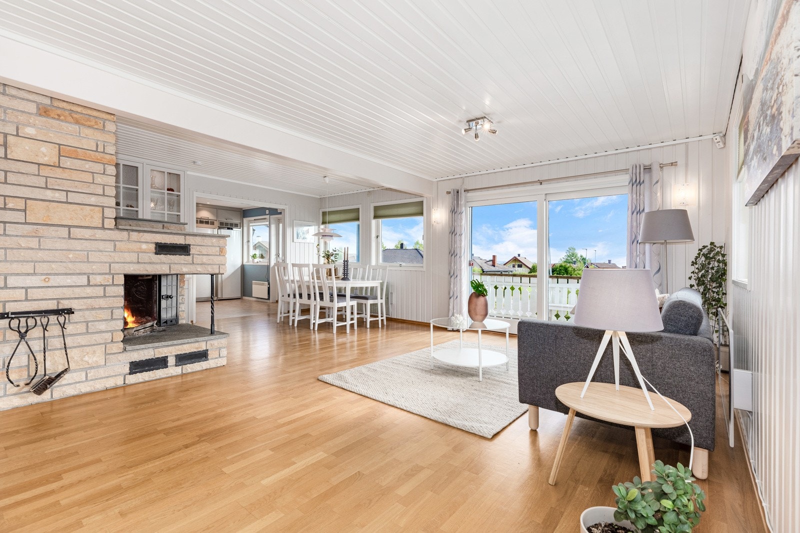 Lys og romslig vinkelstue med ildsted og skyvedør ut til stor terrasse. Galleribilde