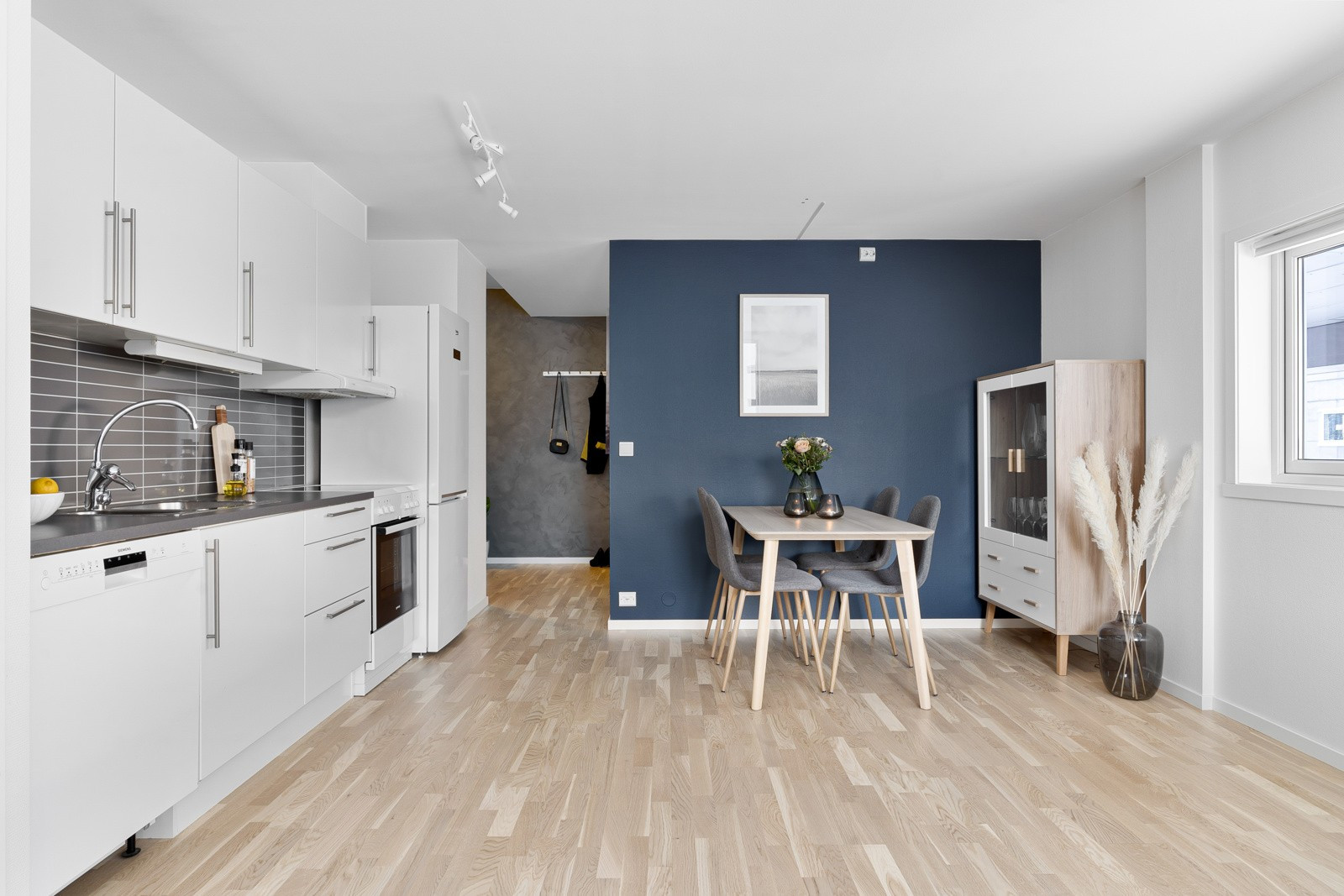 Stue og kjøkken i åpen løsning med god plass for møblering som sofagruppe og spisebord.