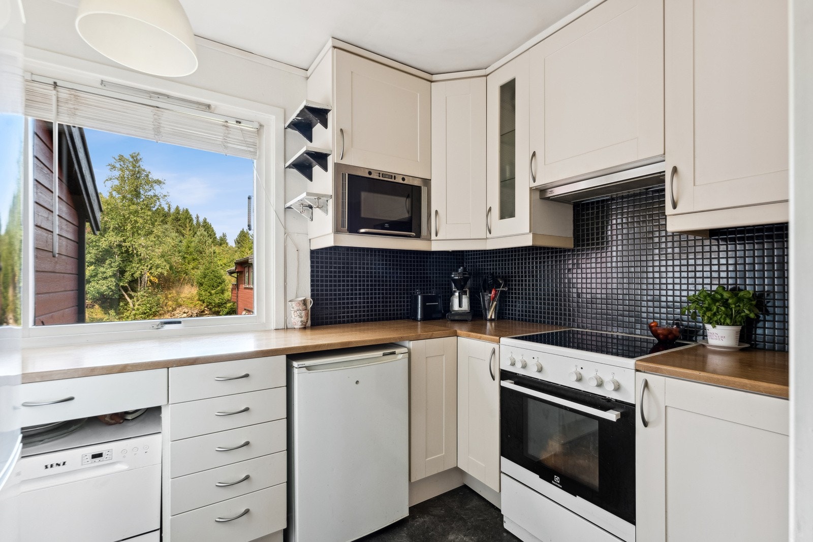 Praktisk kjøkken som er adskilt fra stuen, innredingen er av eldre dato. Galleribilde