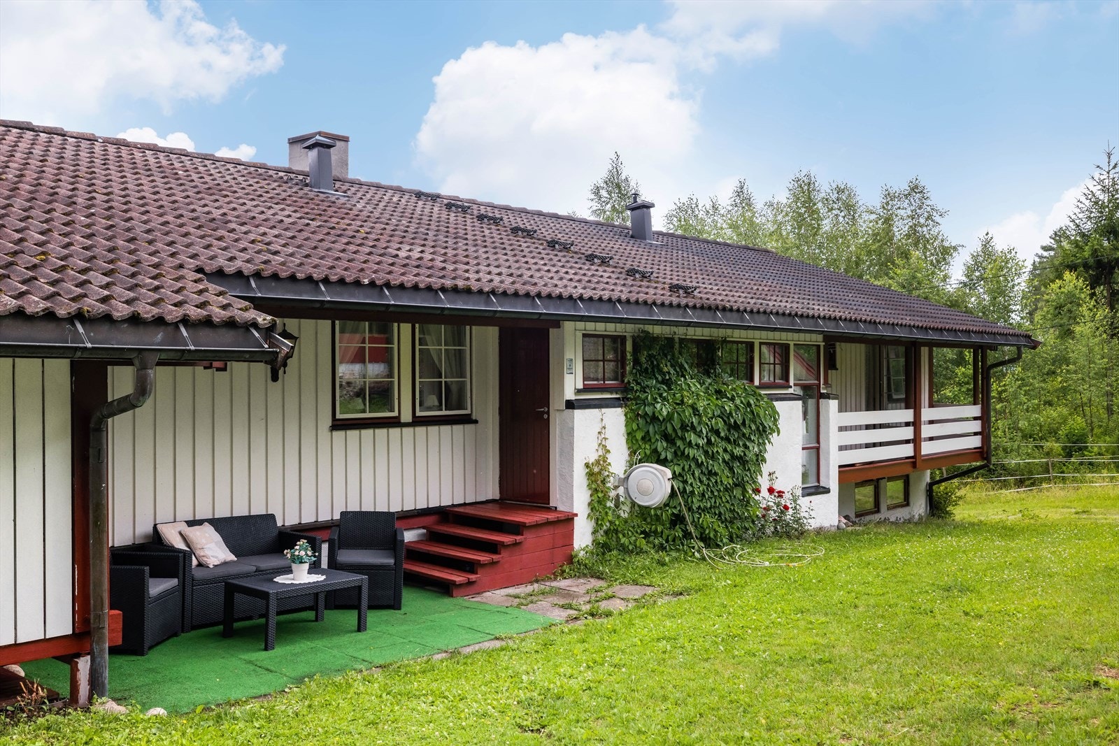 Inngangen til hovedetasje med uteplass lagt med steinheller. Galleribilde