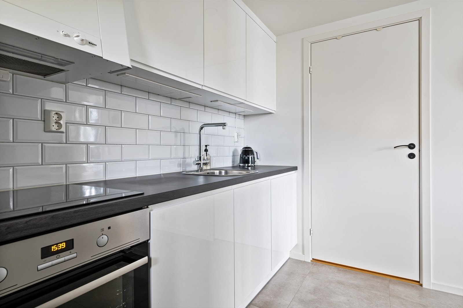 Glatte fronter og laminert benkeplate med fliser over Galleribilde