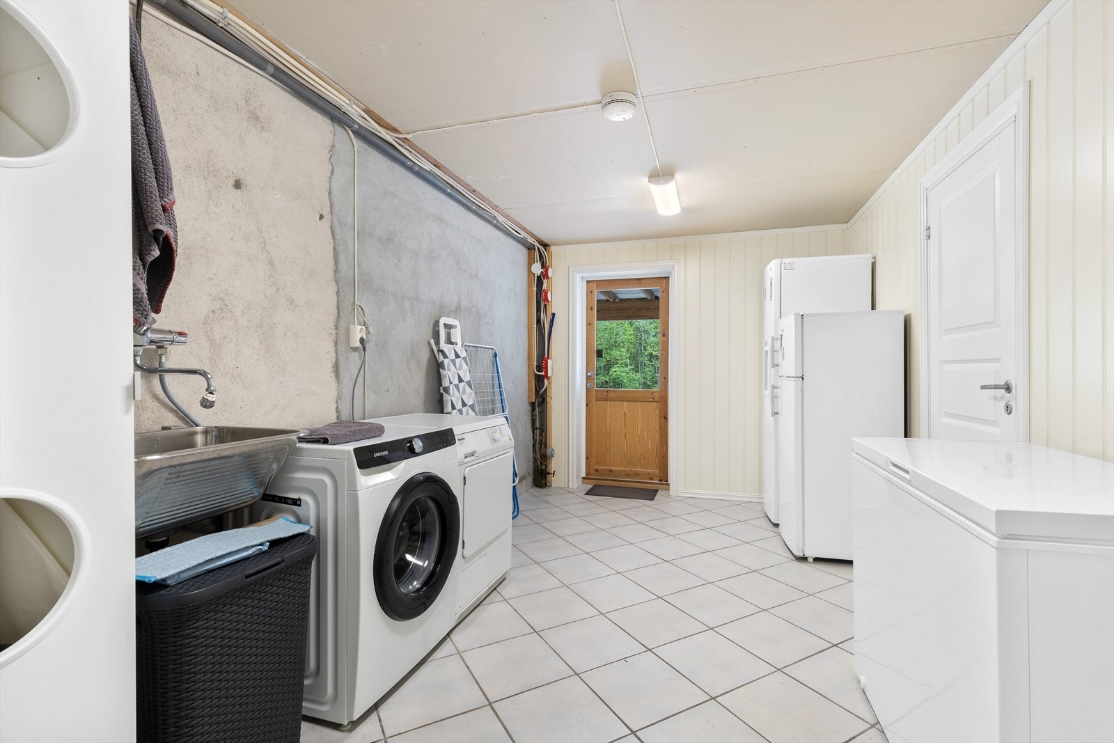 Innredet vaskerom i underetasjen med opplegg for vaskemaskin og tørketrommel. Galleribilde