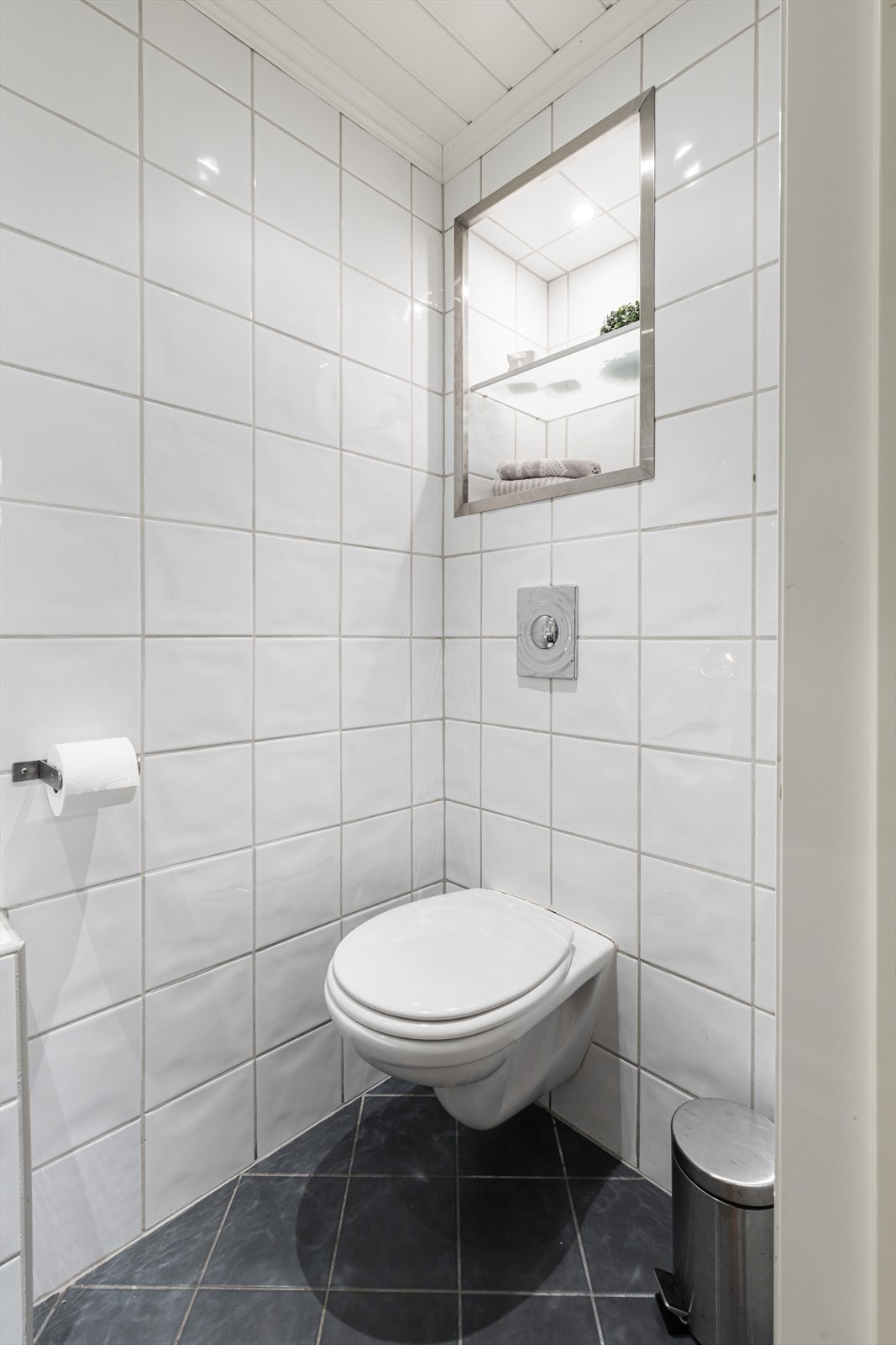 Toalettrommet er innredet med vegghengt toalett og servant på baderomsinnredning. Galleribilde