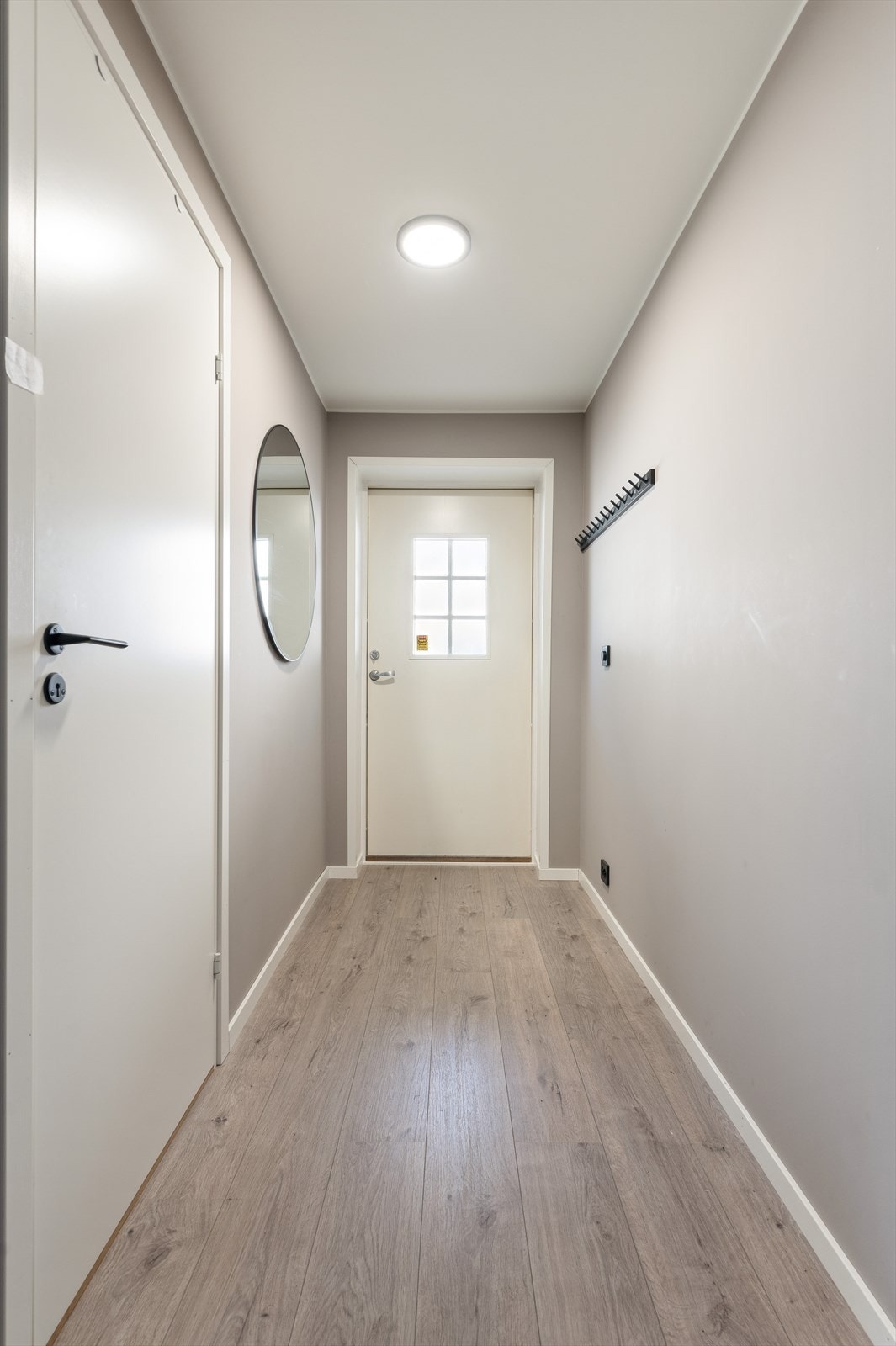 Det er adkomst til boligens første etasje fra bakkenivå og inn i første etasje.
Velkommen inn - her ønskes du velkommen inn i lys entrè med plass til å henge fra deg ytterklær. Galleribilde