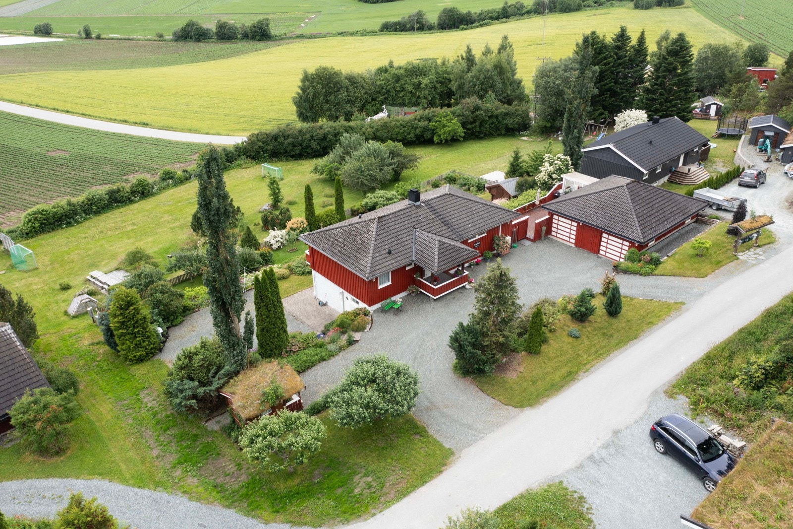 Dronefoto boligen og nærområdet, og felles lekeplass/ballplass nedenfor boligen. Galleribilde