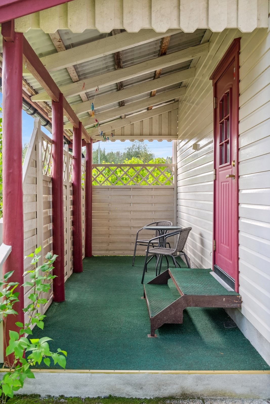 En lun terrasse rett utenfor stua. Den er overbygd og og gir god beskyttelse mot vær og vind Galleribilde