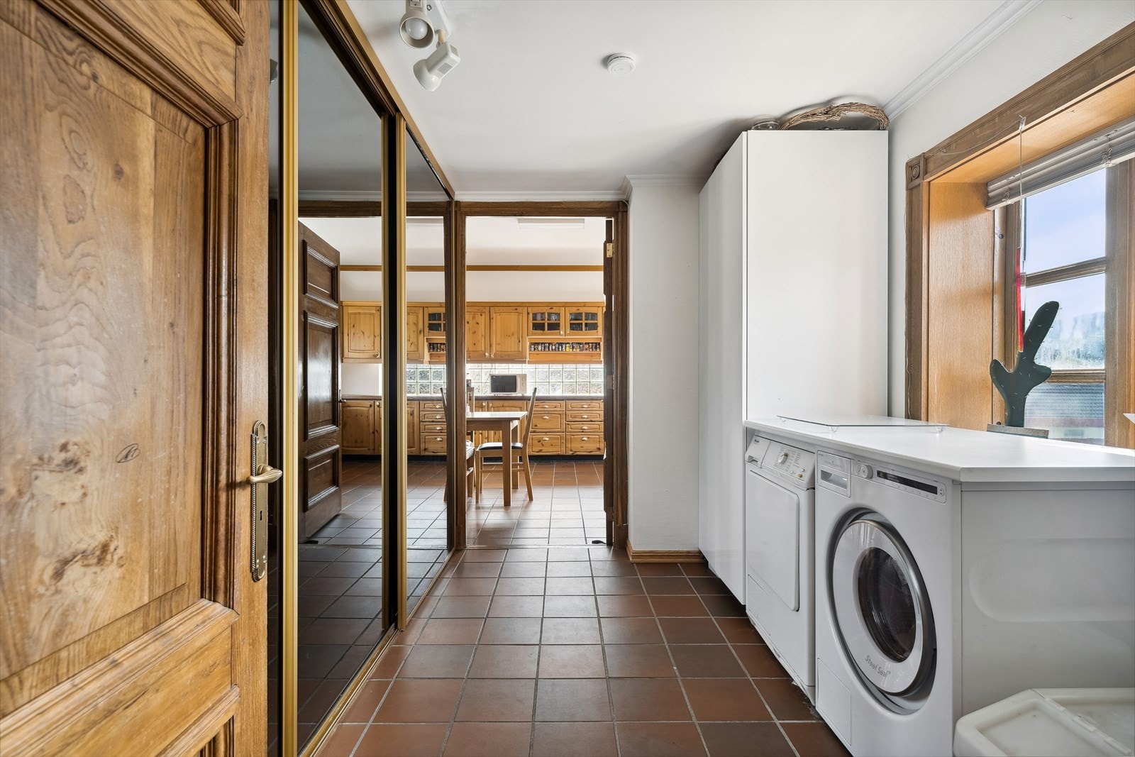 Like ved inngangspartiet har man et praktisk vaskerom med god lagringsplass og gjennomgang til kjøkkenet. Et praktisk rom for barnefamilien. Galleribilde