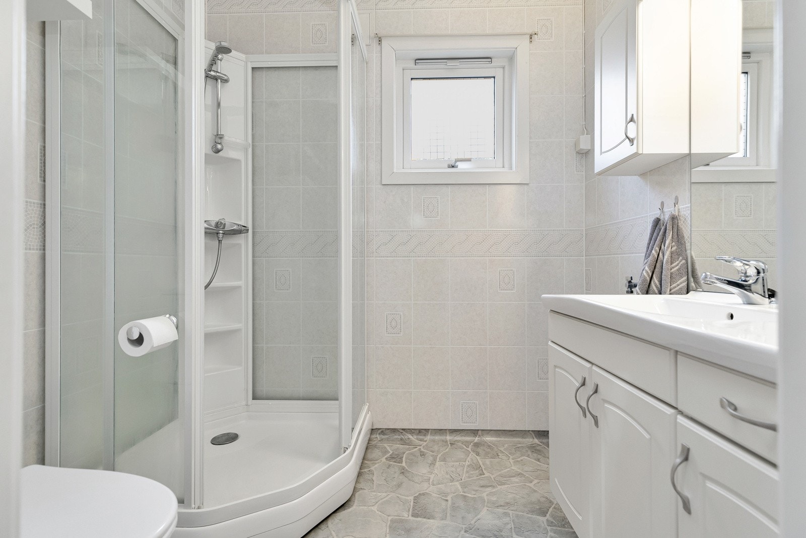 Lyst bad med våtromsplater på vegger og våtromsbelegg på gulv. Galleribilde