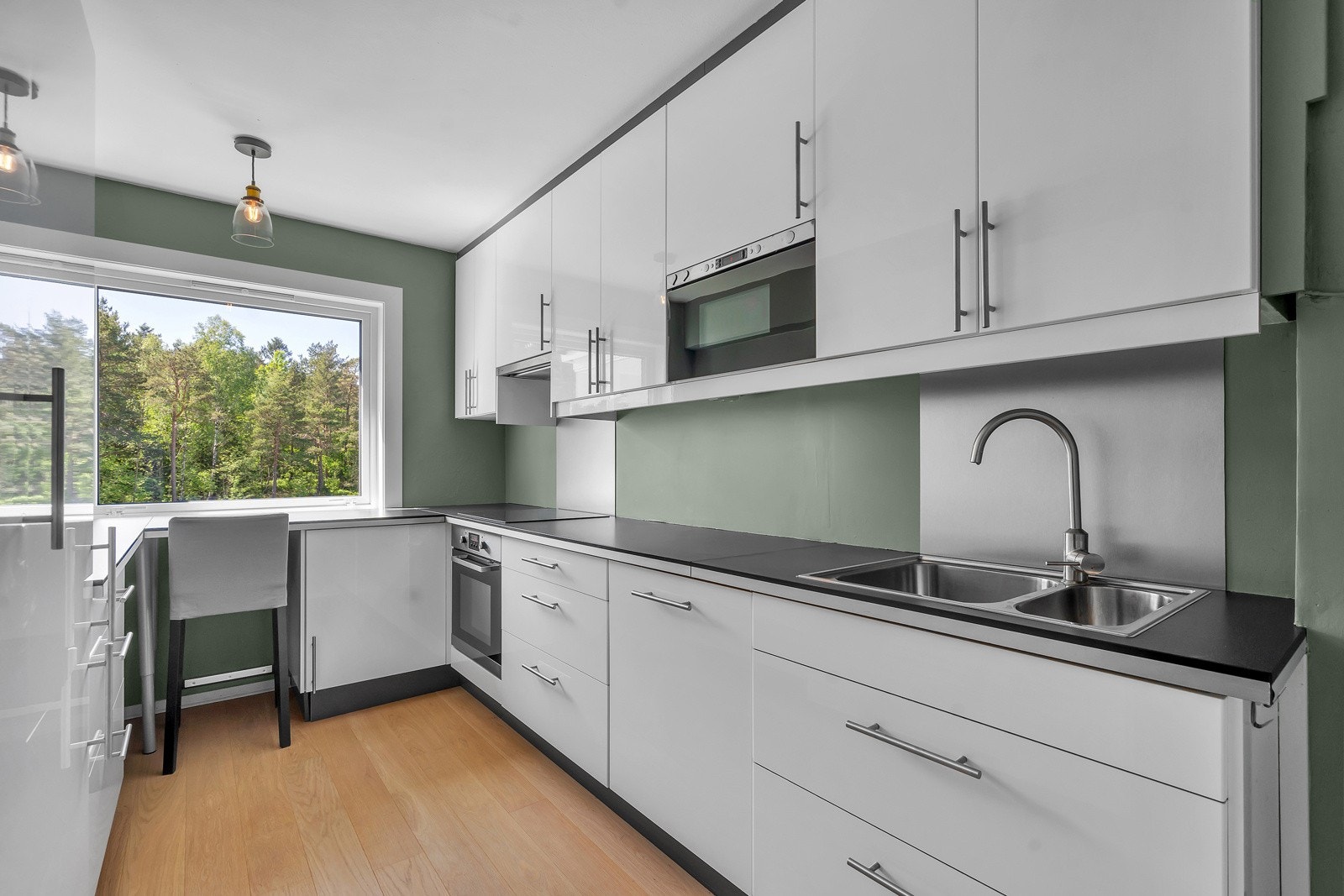 Lekkert hvitt kjøkken med god benk- og skapplass Galleribilde