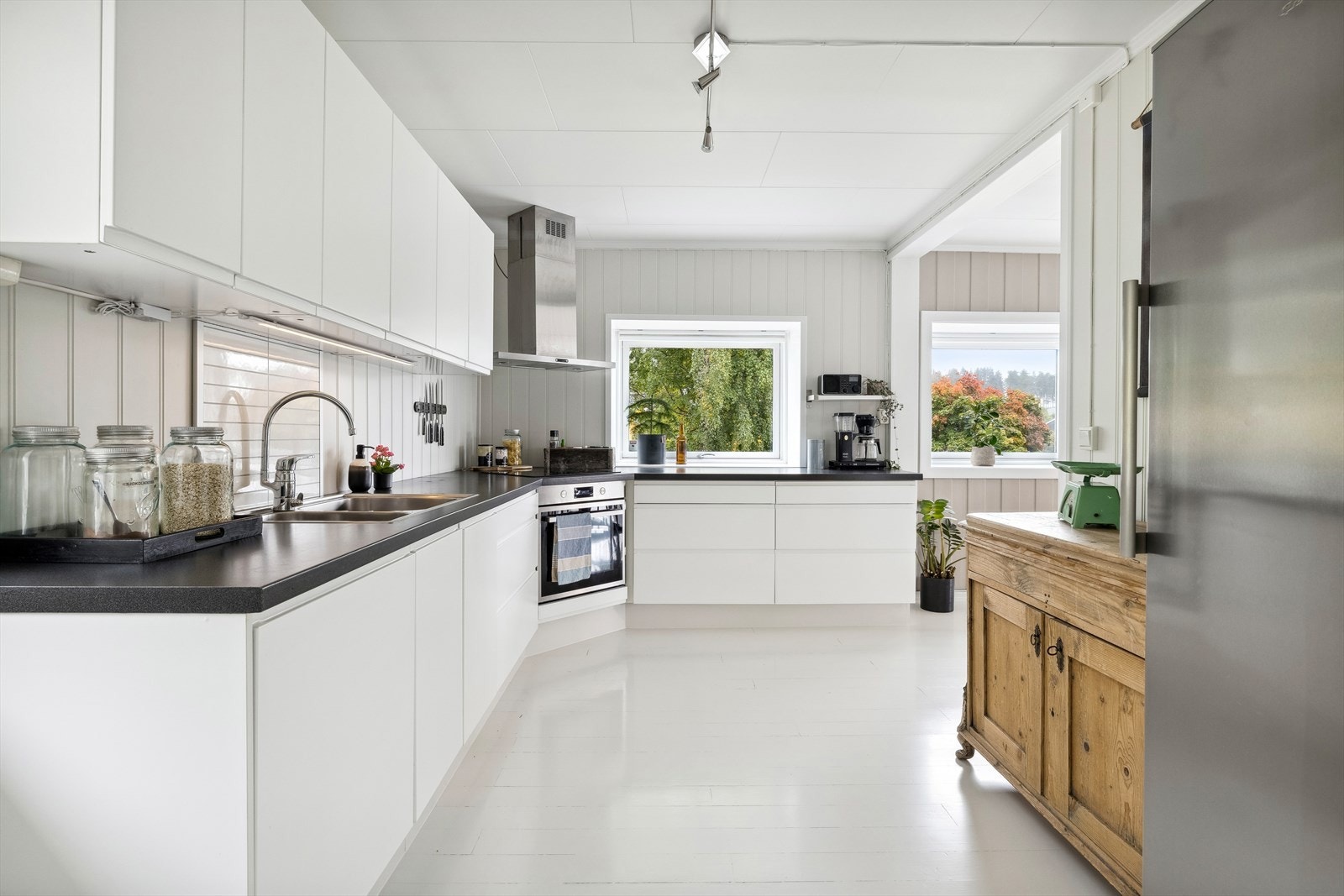 Moderne innredning med slette fronter og laminert benkeplate med nedfelt platetopp og vaskekum. Galleribilde
