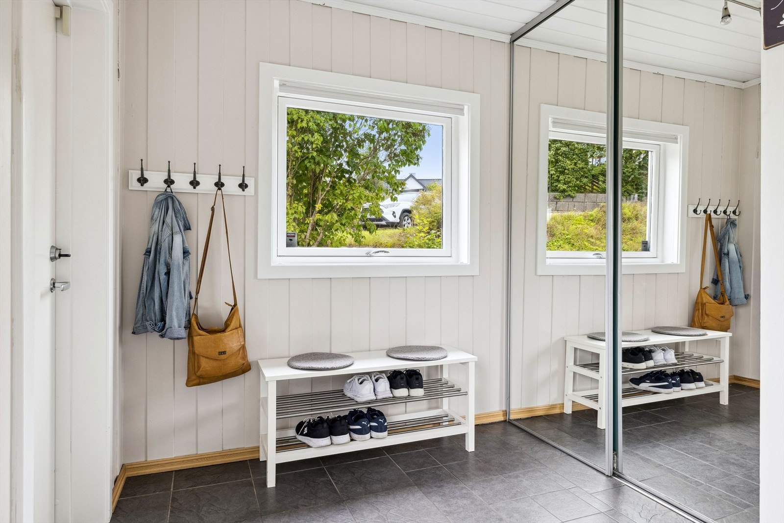 Rommet gir plass for gode oppbevaringsløsninger og er innredet med praktisk skyvedørsgarderobe med speilfronter. Galleribilde