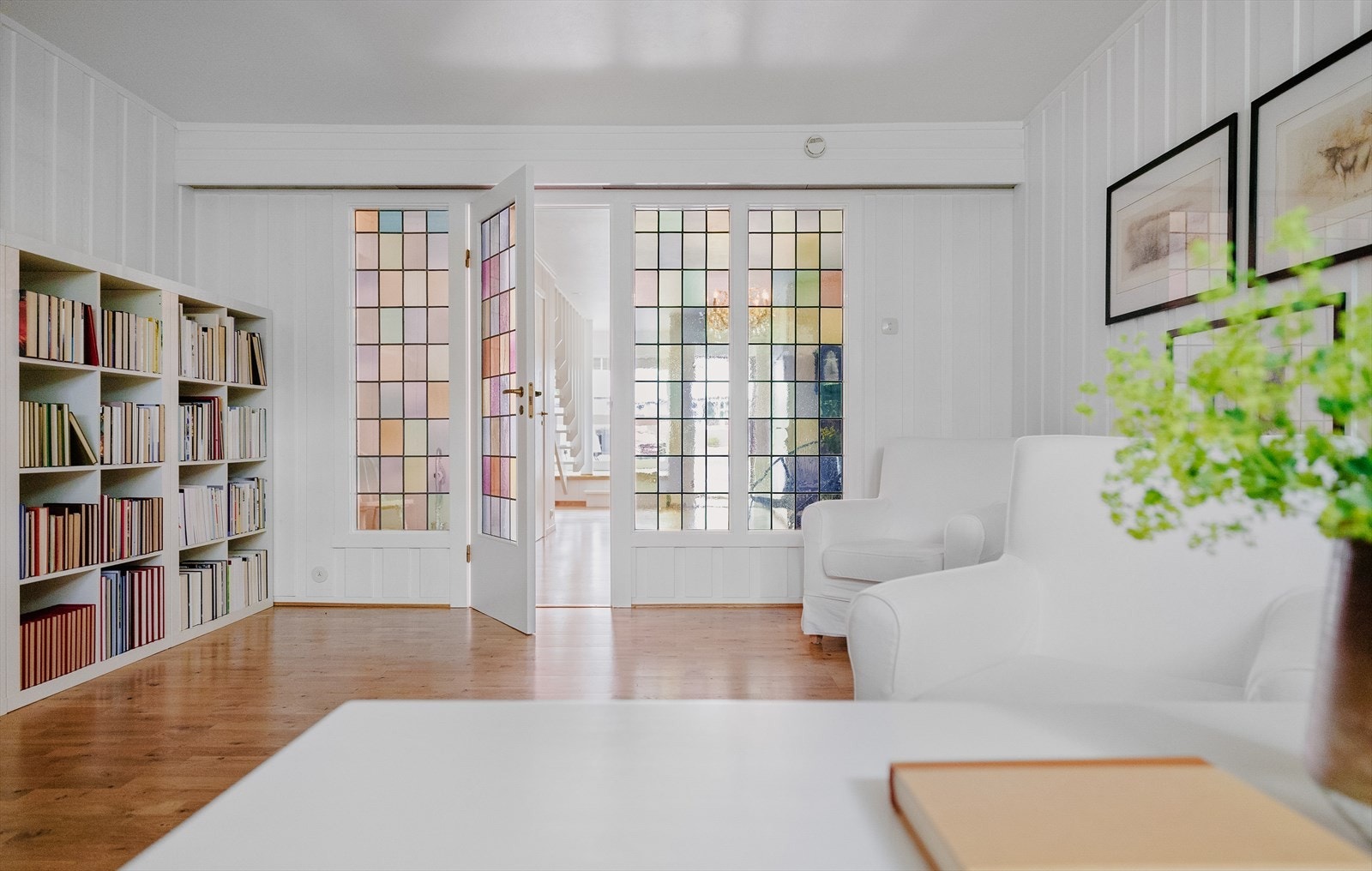 De fargede blyglassene i døren og vinduene inn til peisestuen forteller hva vi har i vente, for her har man vært flinke og tatt vare på originale detaljer. Galleribilde